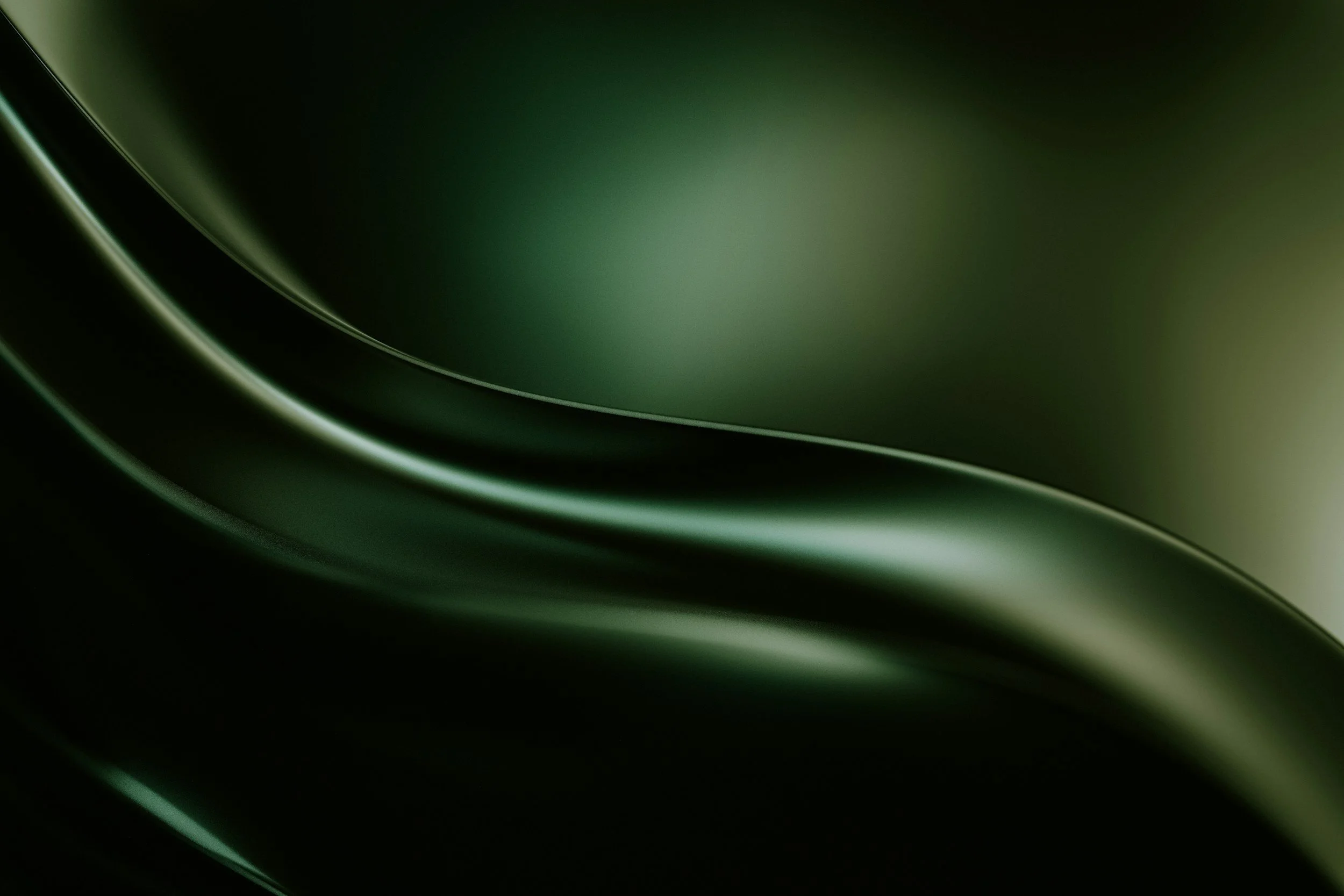 Close-up of a sleek, dark green, curved metallic surface with smooth reflective highlights.