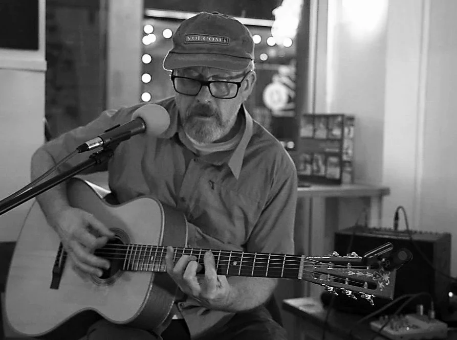 Greg Duckworth playing guitar and singing at a Kendal gig