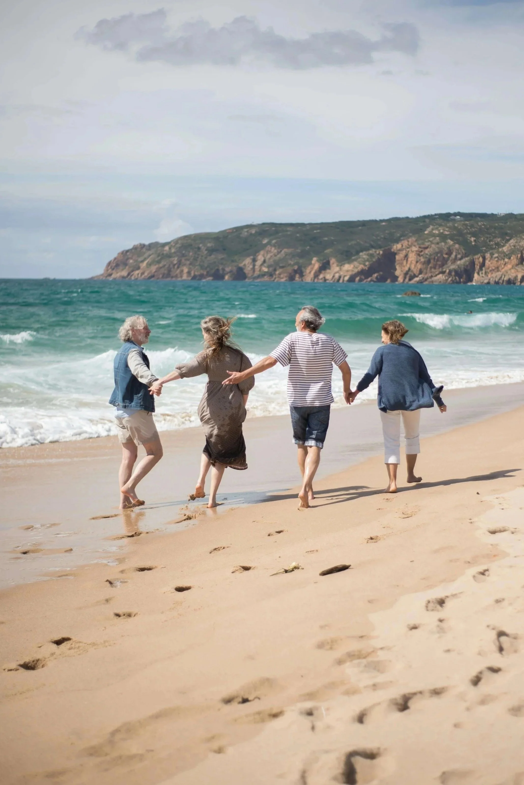 Image of a multi-generational family barefoot on a sunny beach