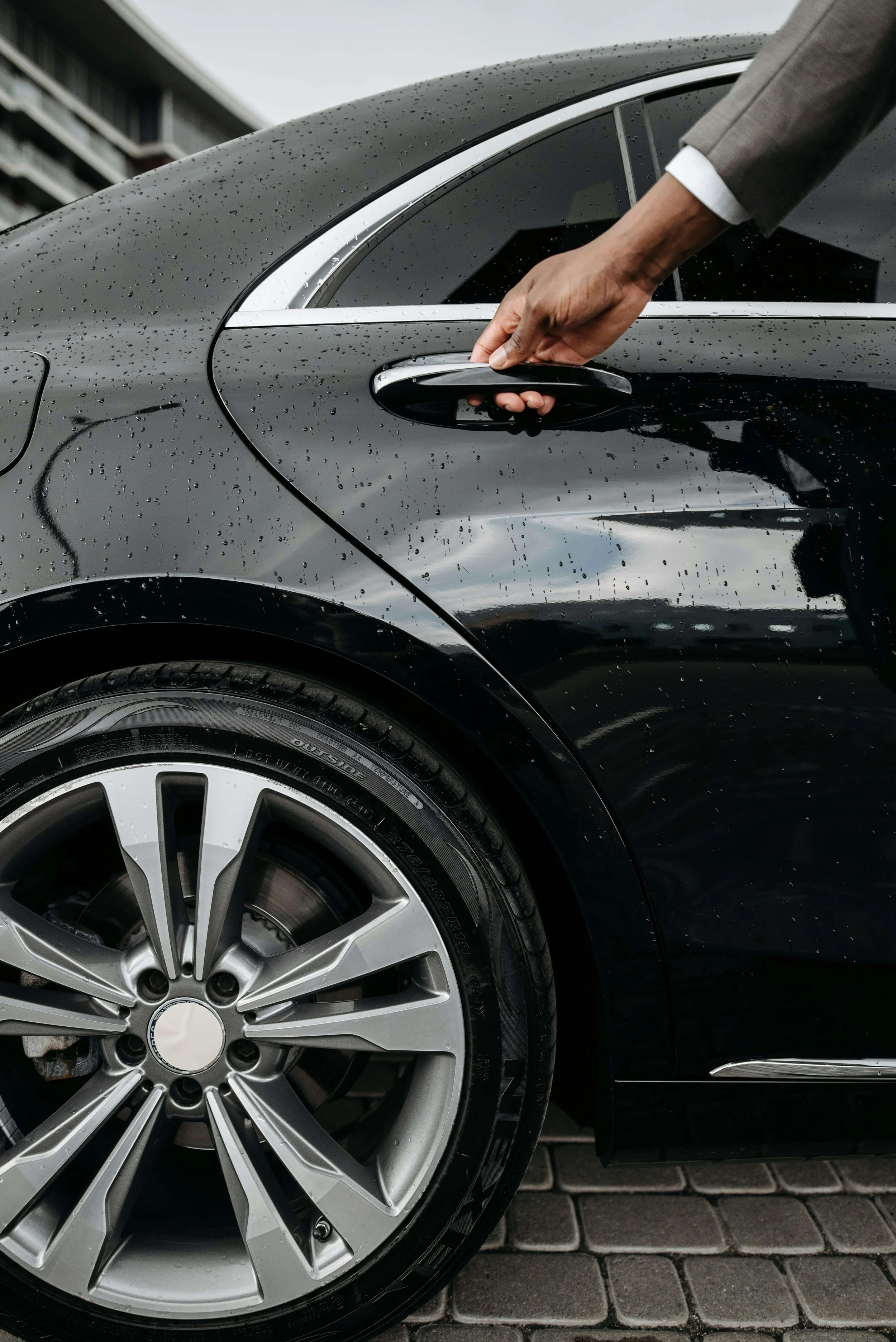 Image of a chauffeur opening the door of a luxury car