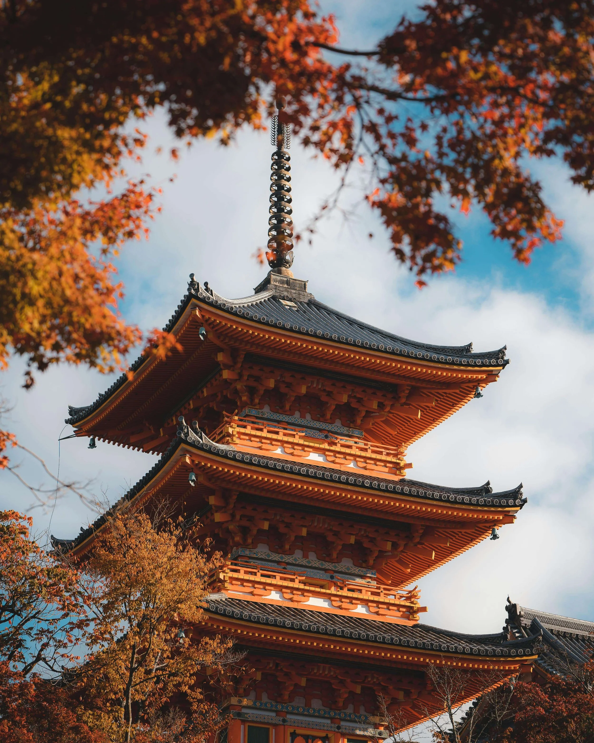 Traditional Kyoto temple surrounded by seasonal foliage in Japan.