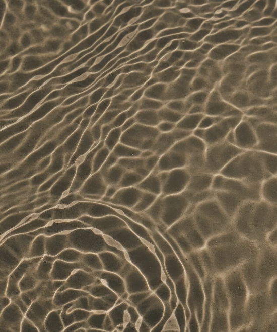 Close-up of water with ripples and reflections on the surface.