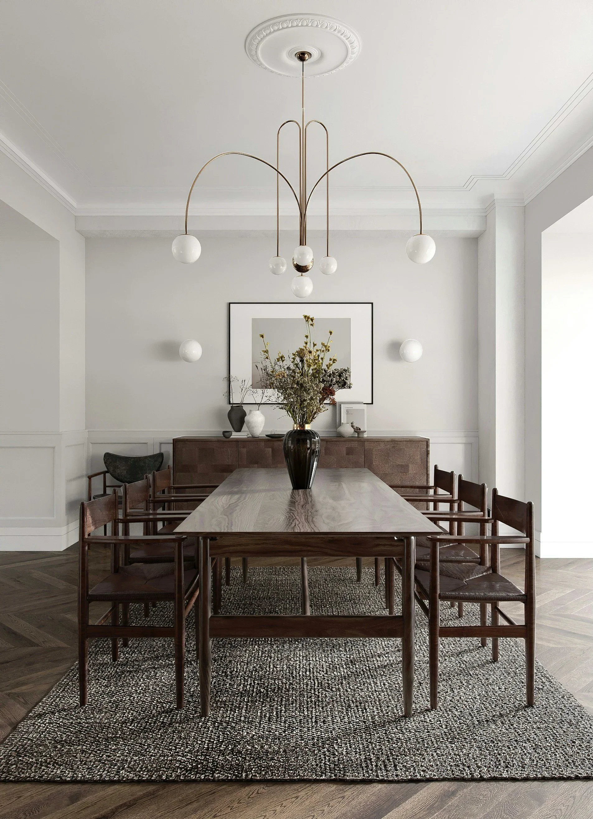 A minimalist dining room with a wooden table, six matching chairs, a black vase with dried flowers, a framed picture on the wall, a wooden sideboard, and a modern chandelier with multiple globes hanging from the ceiling.