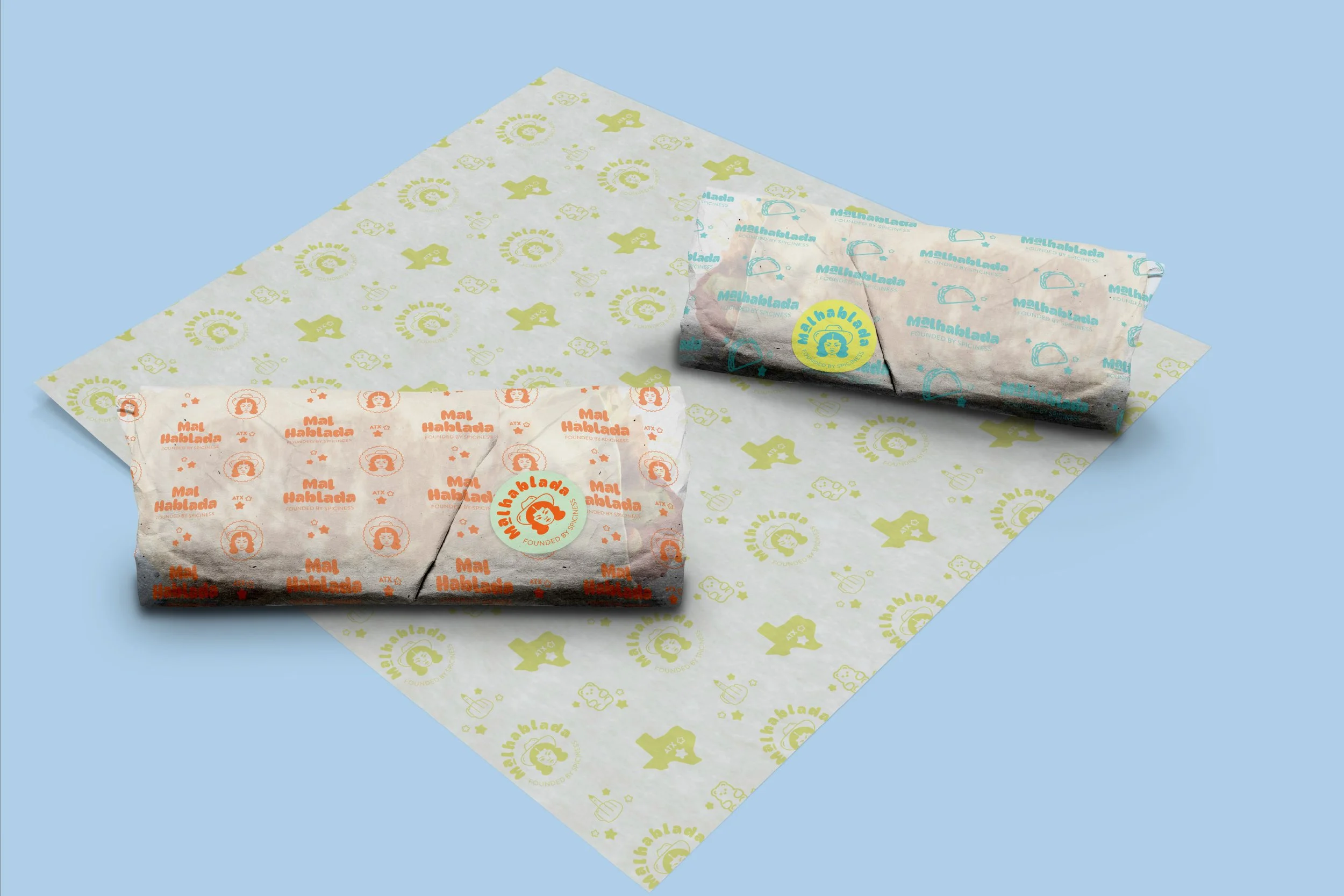 Three stacks of crumpled wrapping paper with colorful logos and text, placed on patterned paper with similar logos and text on a light blue background.