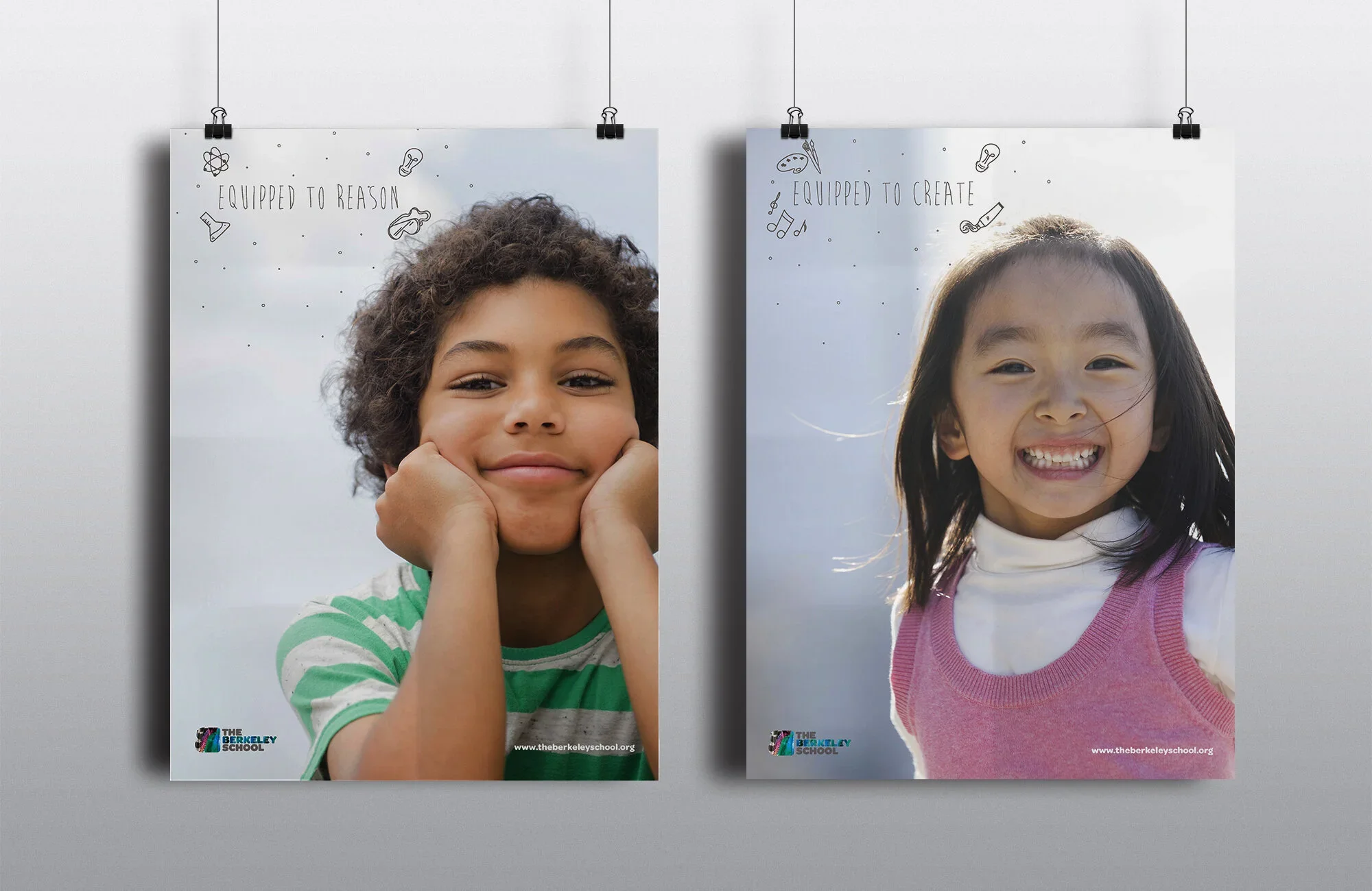 Two posters hanging on a wall featuring smiling children. The left poster shows a  with curly hair resting her chin on her hands, wearing a green and white striped shirt. The right poster shows a girl with straight black hair, smiling widely, wearing a pink vest over a white shirt. The posters have the text "Equipped to Reason" on the left and "Equipped to Create" on the right, with small drawings of science, art, and music icons. Both posters include the logo and website of The Berkeley School.