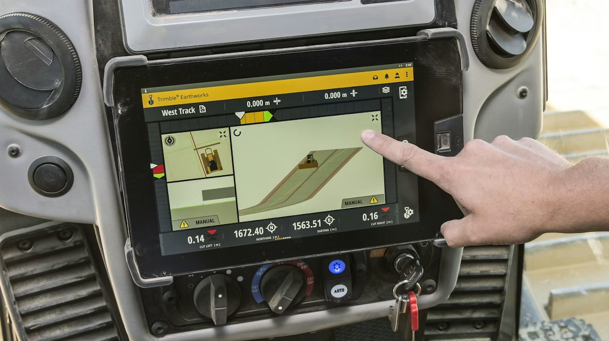 A person using a GPS device mounted on a vehicle dashboard, with their finger pointing at the screen that displays a map and various navigation details.