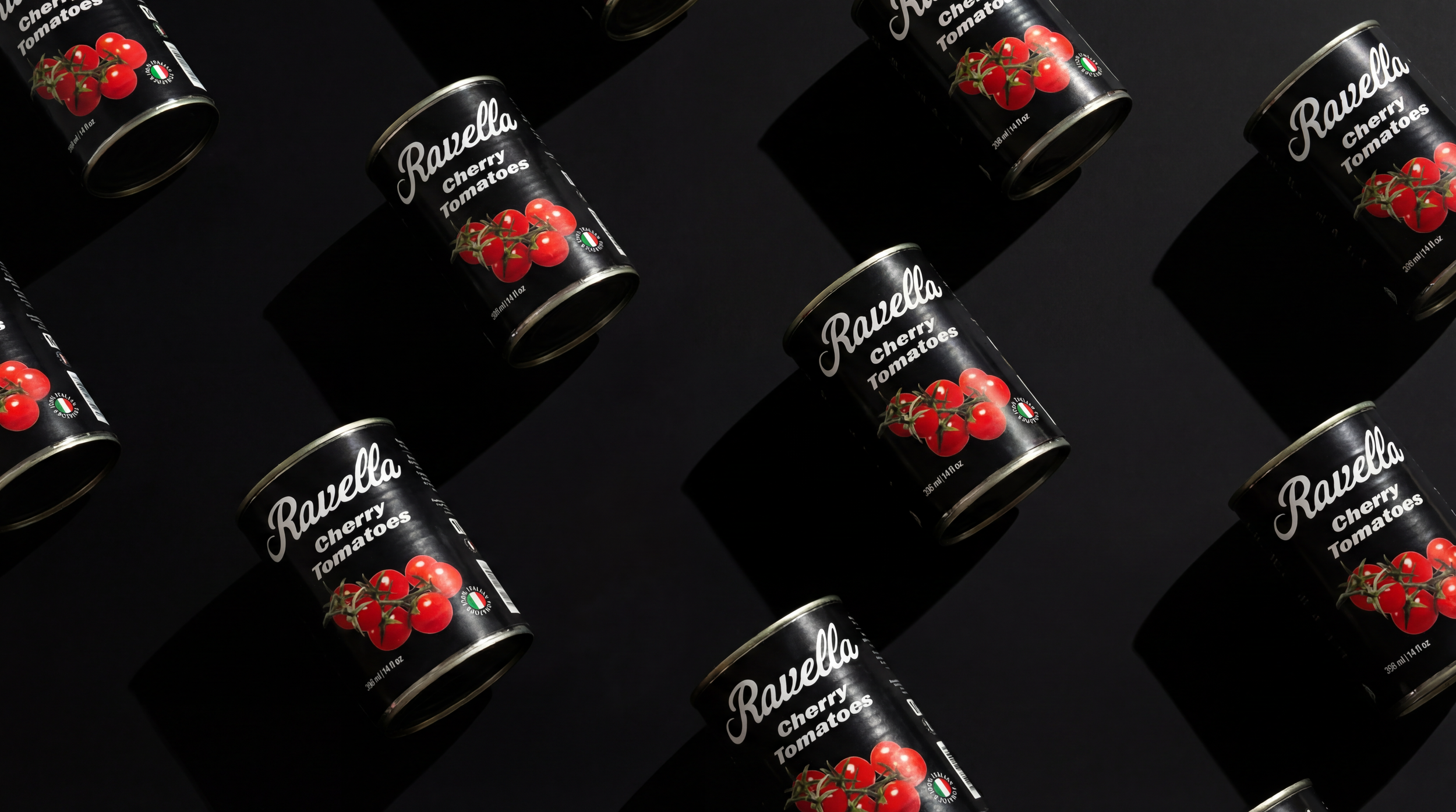 Multiple cans of Ravella cherry tomatoes arranged on a black surface with shadows.