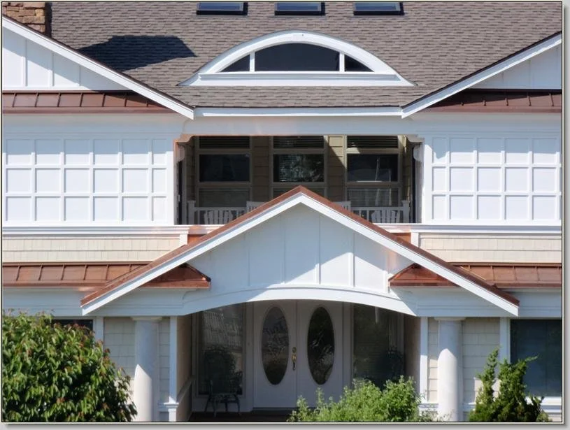 Front view of a two-story house with white siding, brown roof, and a covered porch entrance.