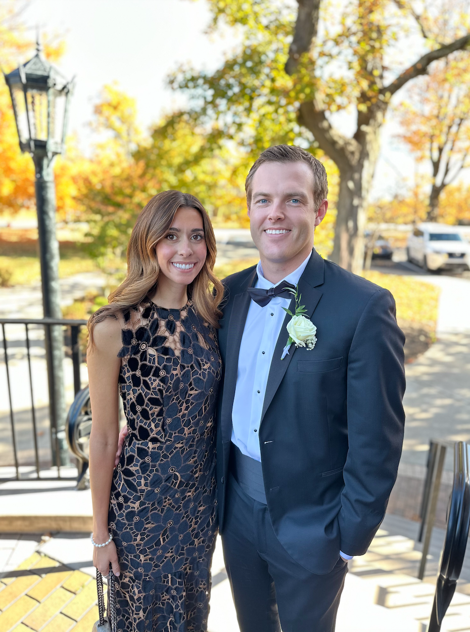 man and women with trees and lightpole in background smilling