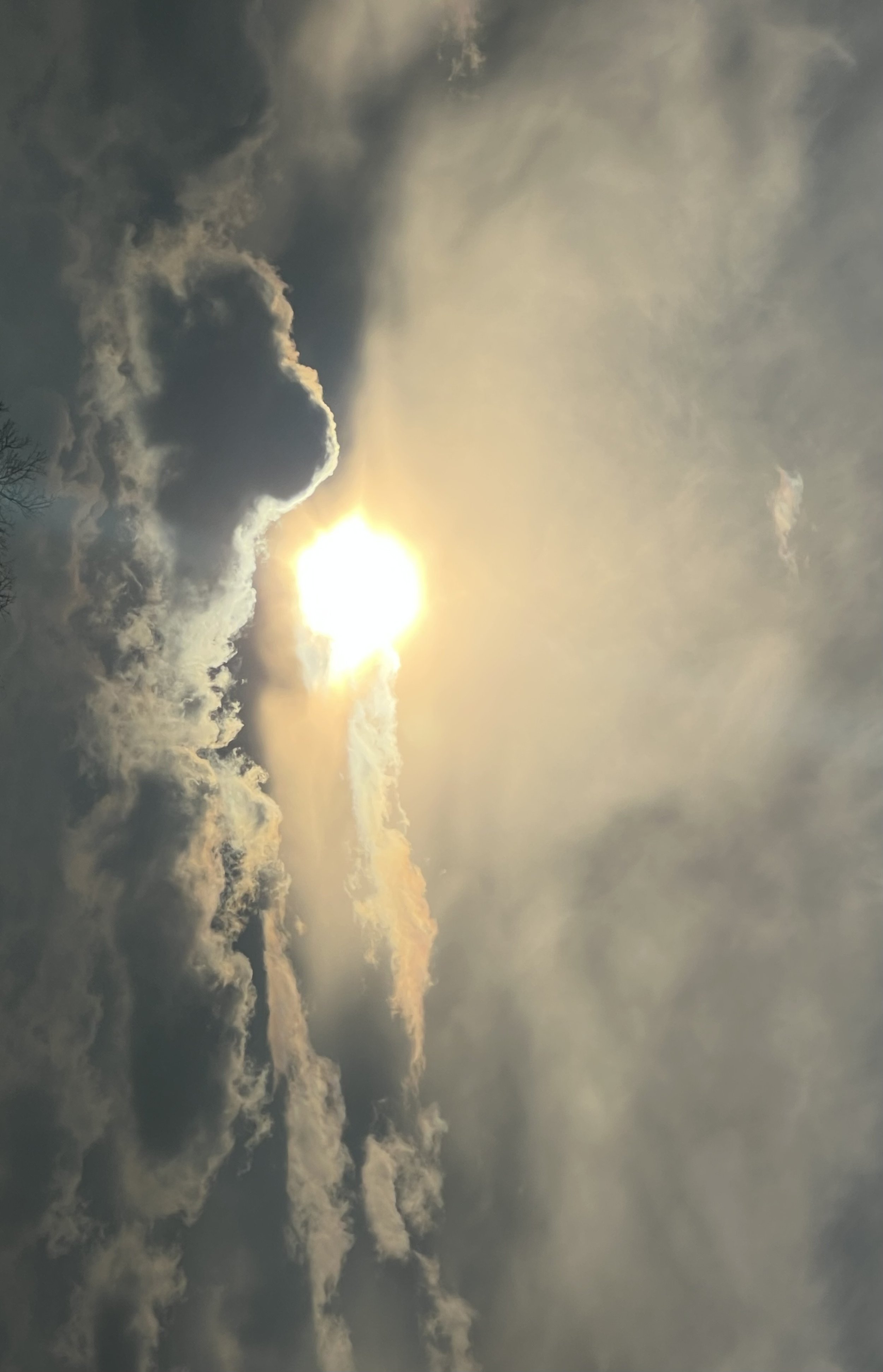 Sun partially obscured by clouds in a cloudy sky