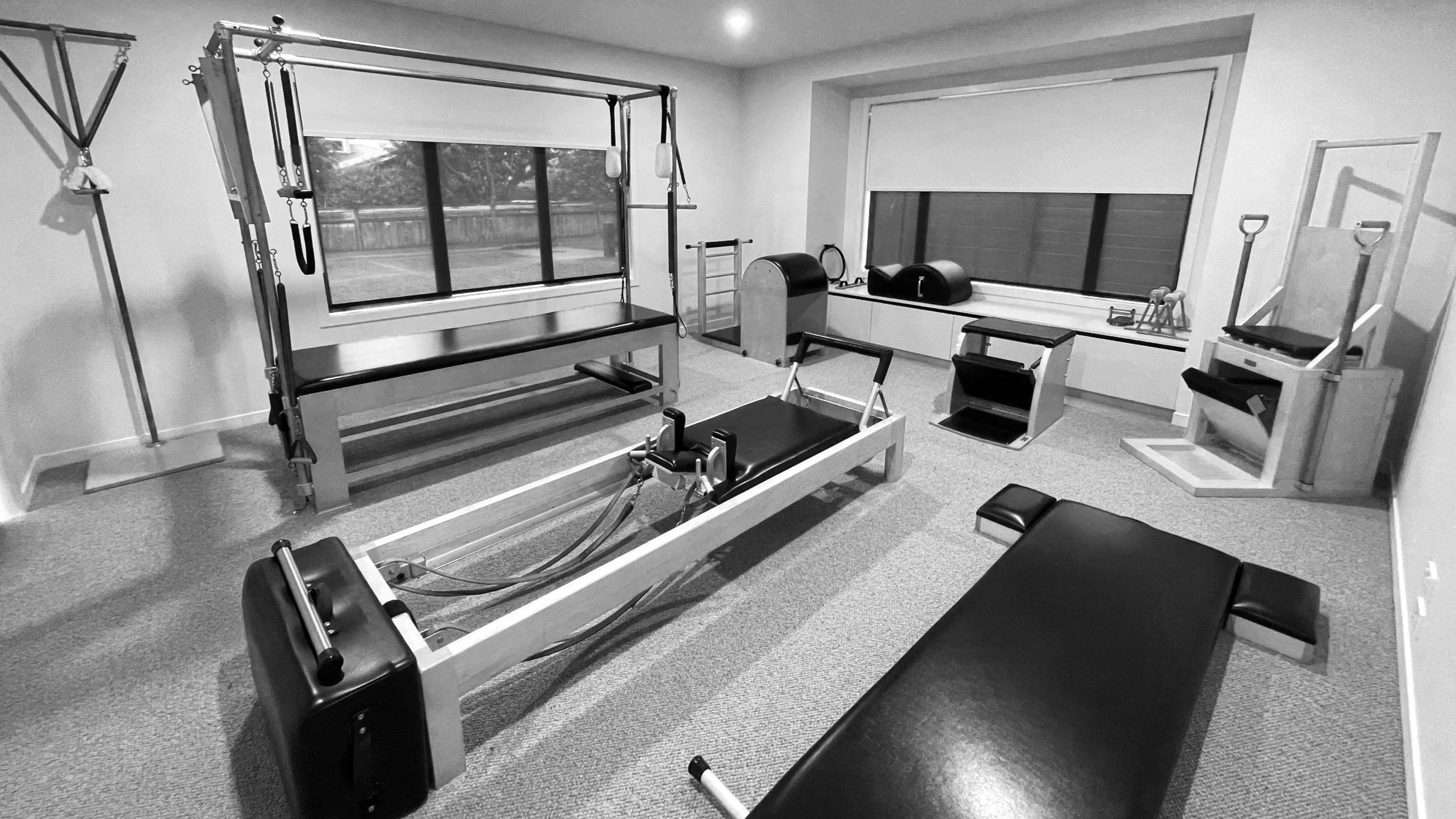 Welcoming home studio Cambridge Park with Pilates reformer, cadillac, wunda chair, ladder barrel, high chair, large windows and workout accessories.