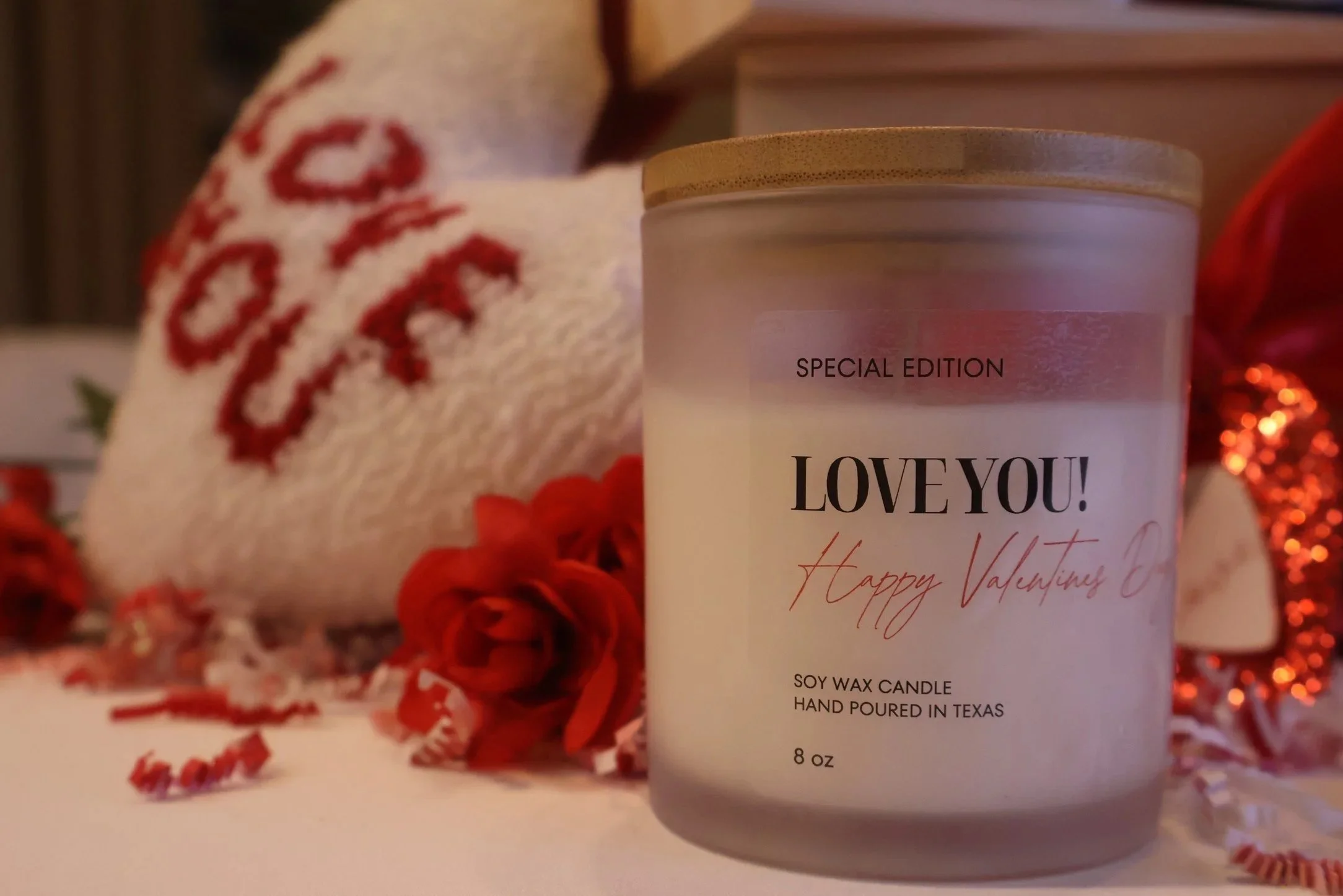 Valentine's Day themed scene with a candle labeled 'LOVE YOU! Happy Valentine's', surrounded by red roses, a white sock with red lettering, and red and white decorations.