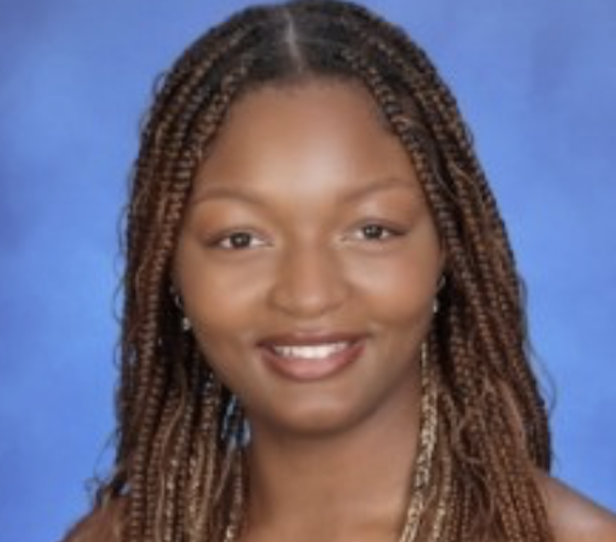 A smiling woman with braided hair against a blue background.