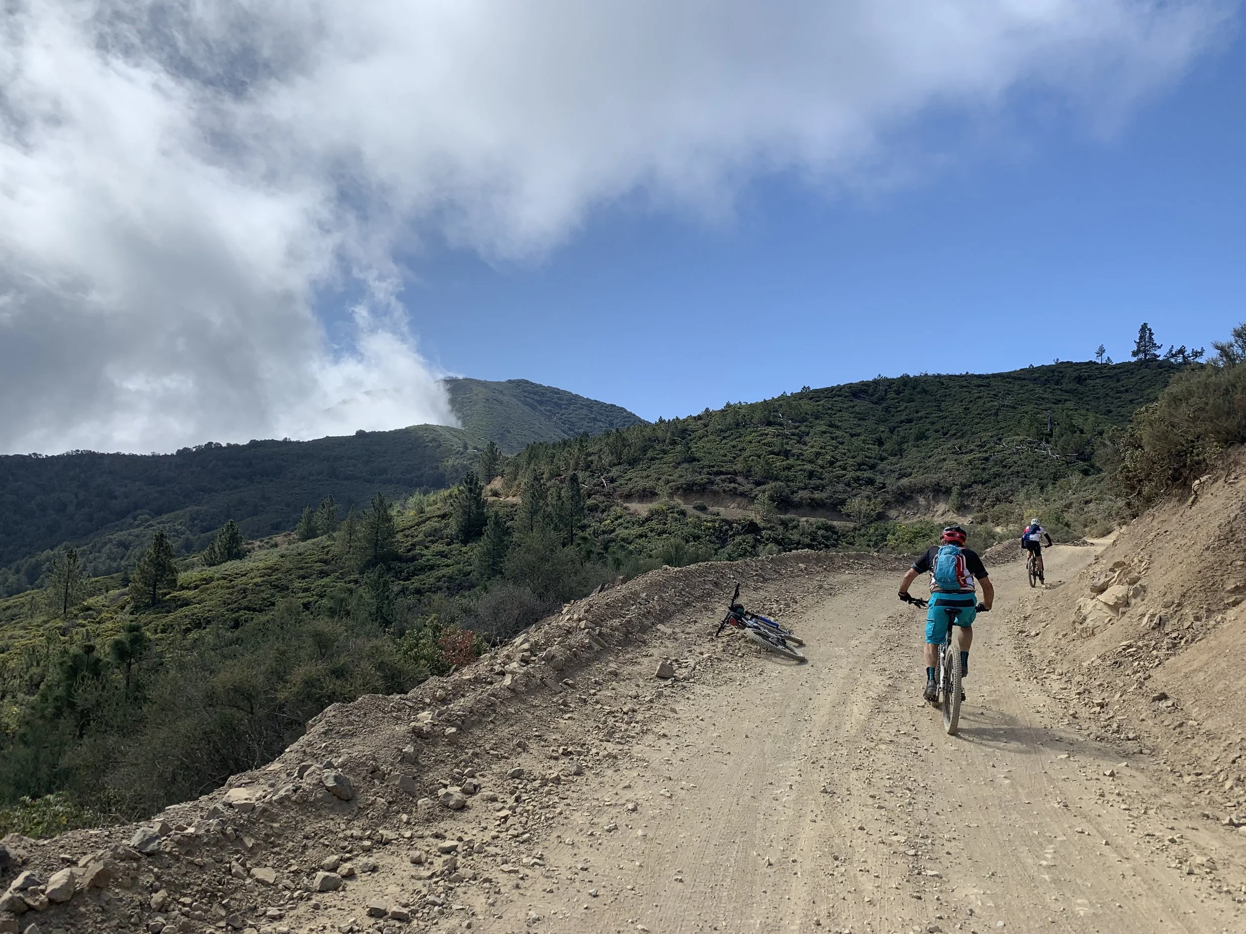 The pavement returns to dirt on Maple Springs Truck Trail. Modjeska Peak, obscured by clouds, looms above.