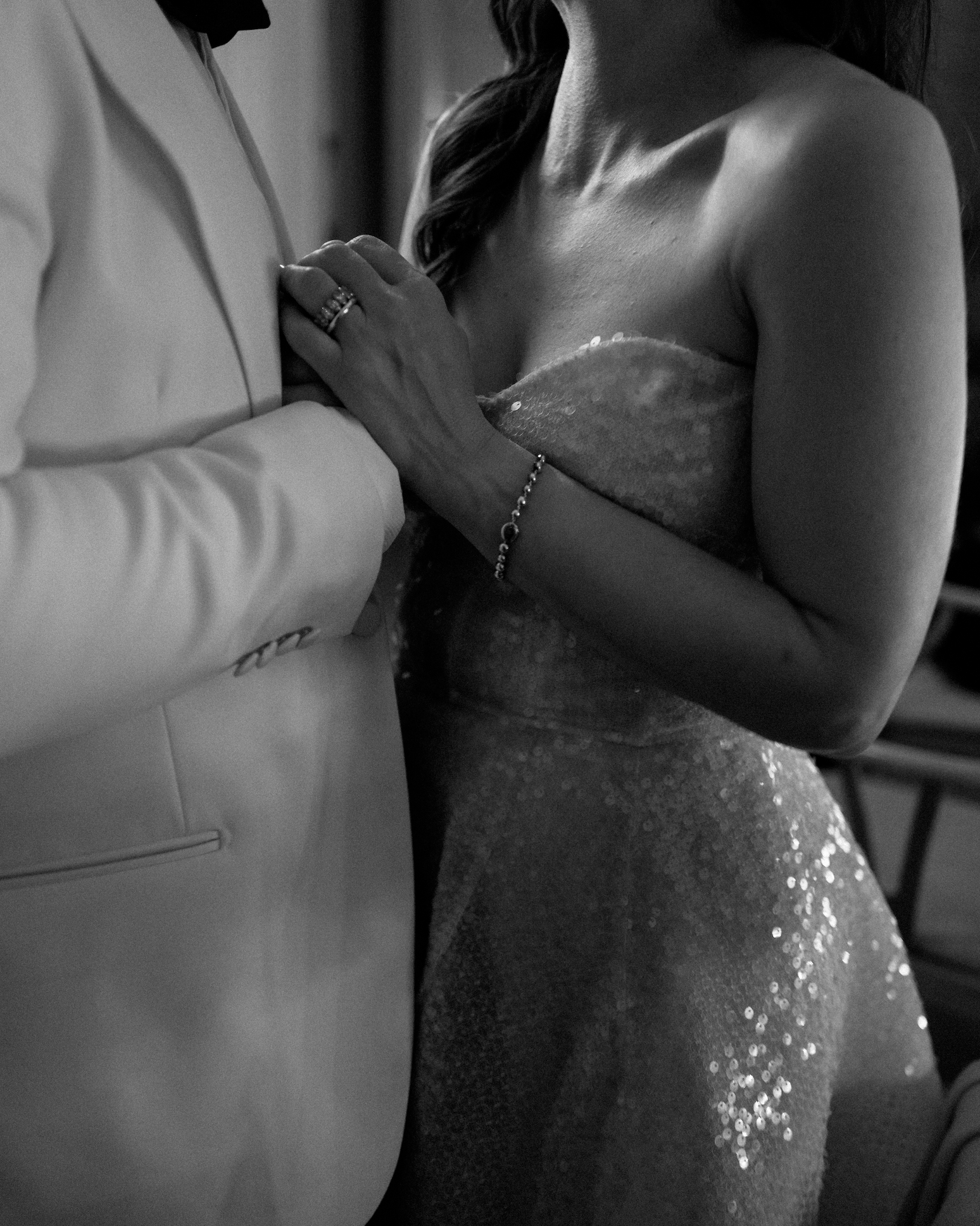 A bride and groom in a close, intimate moment during their wedding, holding hands and standing close together.