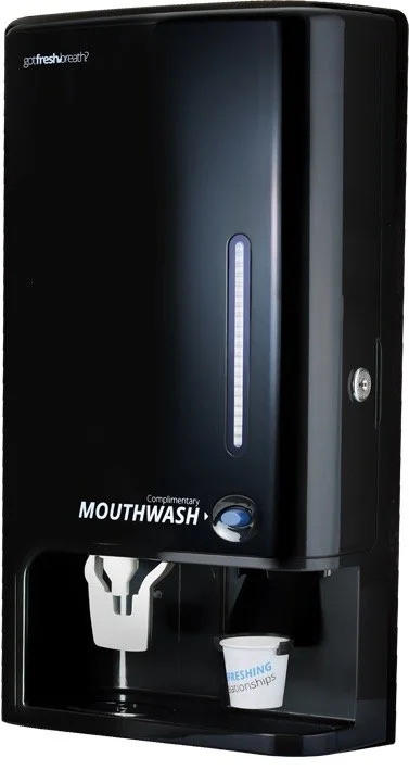 Black wall-mounted automatic mouthwash dispenser with a cup underneath and a blue indicator LED