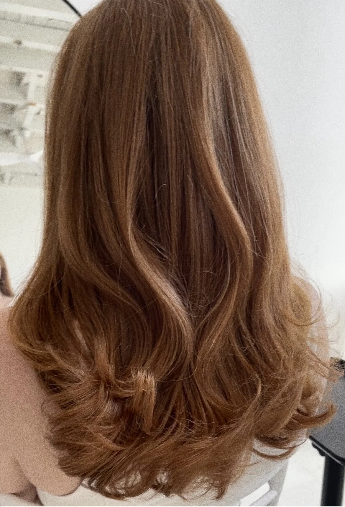 Back view of a woman with long, wavy, red hair