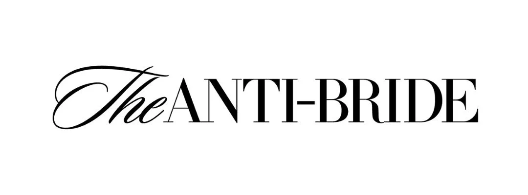 Typography logo reading 'The Anti-Bride' in black cursive and serif fonts on a white background.