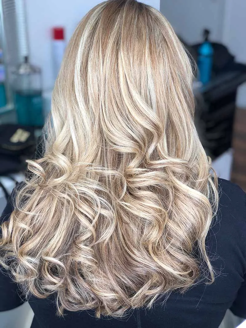 Elegant, voluminous curls and bright, fresh blonde hair color 
