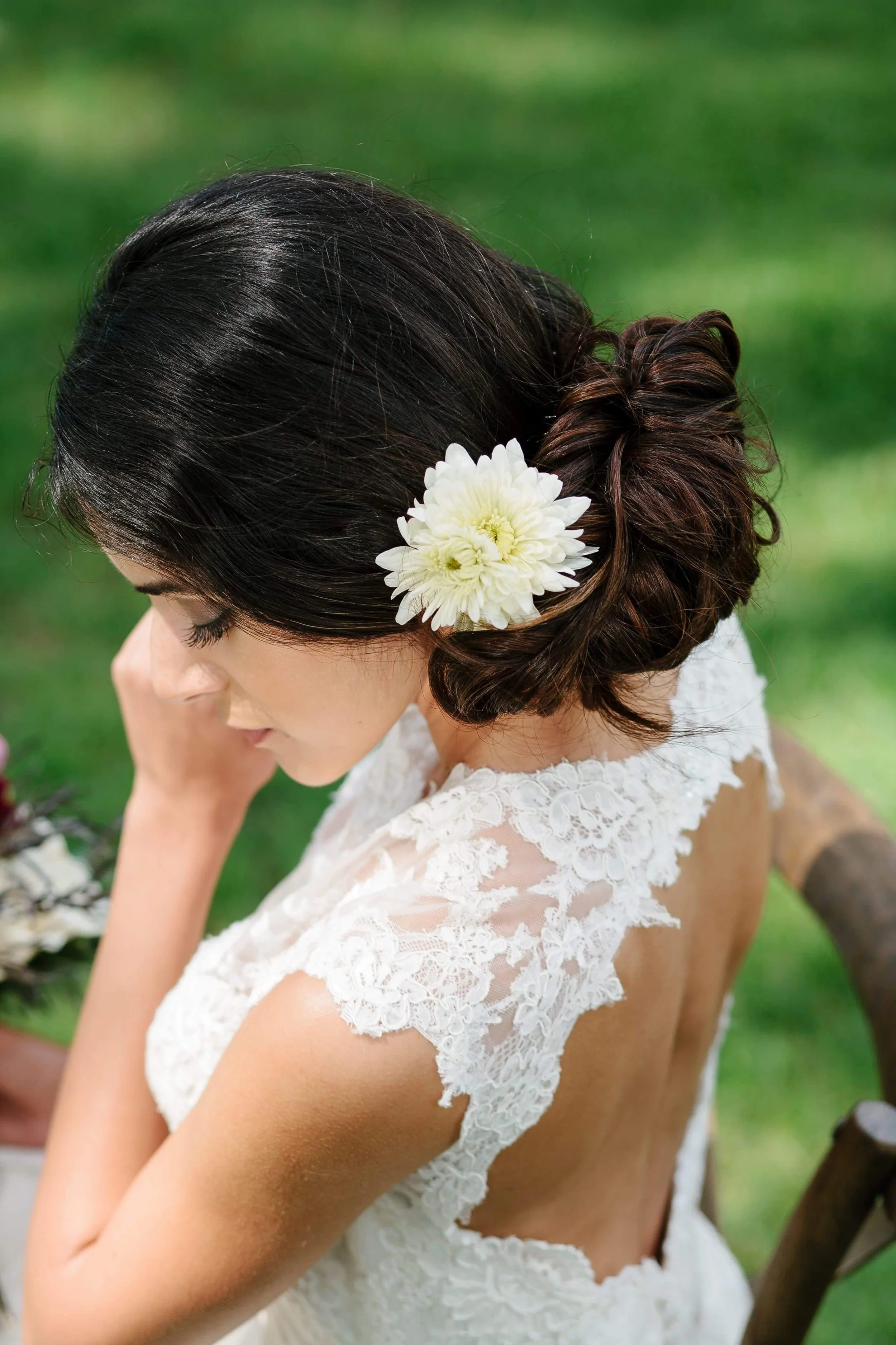 Bride with braided updo and a white flower hairpiece, showcasing soft waves and natural bridal makeup by Spokane and Coeur d’Alene bridal hair and makeup artist Terri Reece Studios.