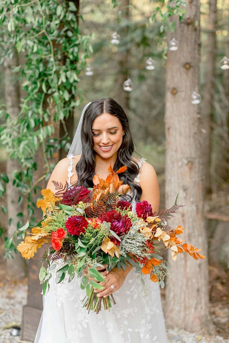 Bride with long, flowy waves posing with large bouquet - Wedding hair and makeup done by Terri Reece Studios