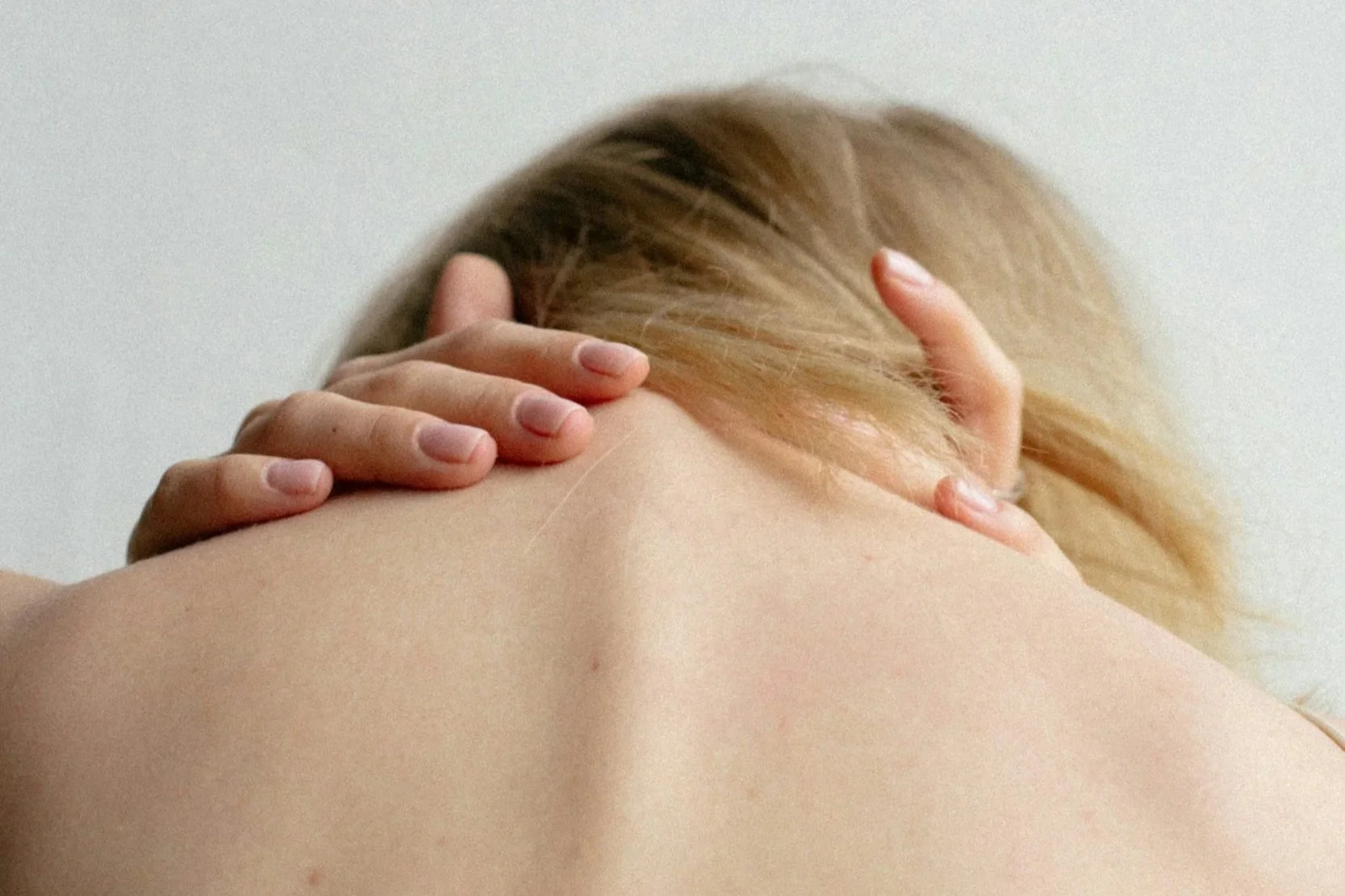 Woman in pain holding her neck and back