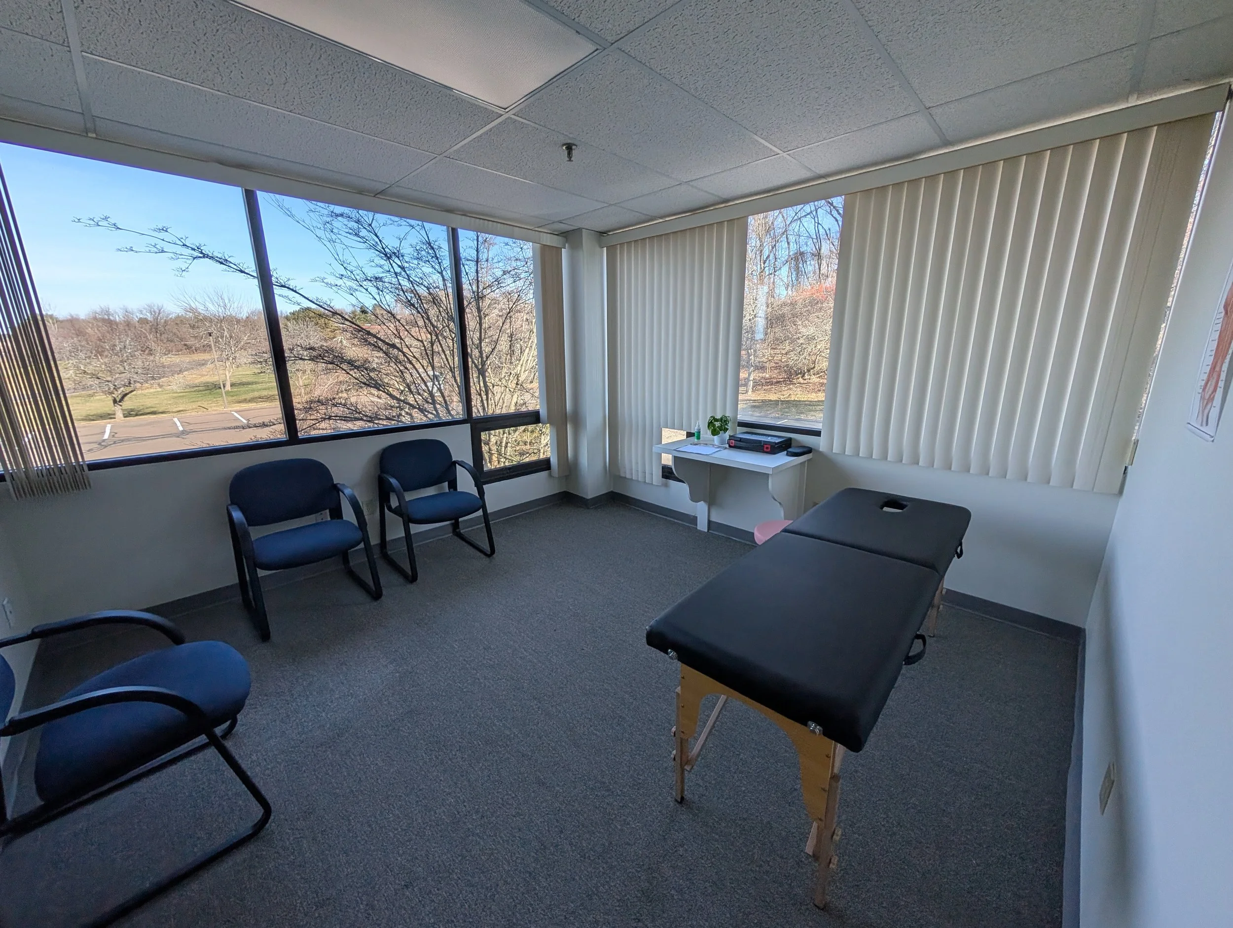 Exam and treatment room with patient table at Alleviate Pain and Wellness
