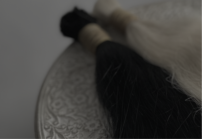 a dark overlay image of hair brown and blonde hair extensions on a table