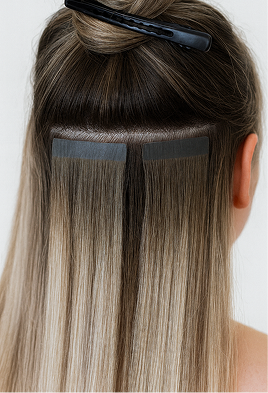 back of woman's head showing tape in hair extensions