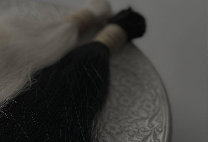 a dark overlay image of hair brown and blonde hair extensions on a table