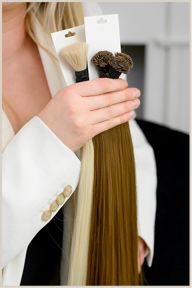 a hand holding bundles of hair extensions