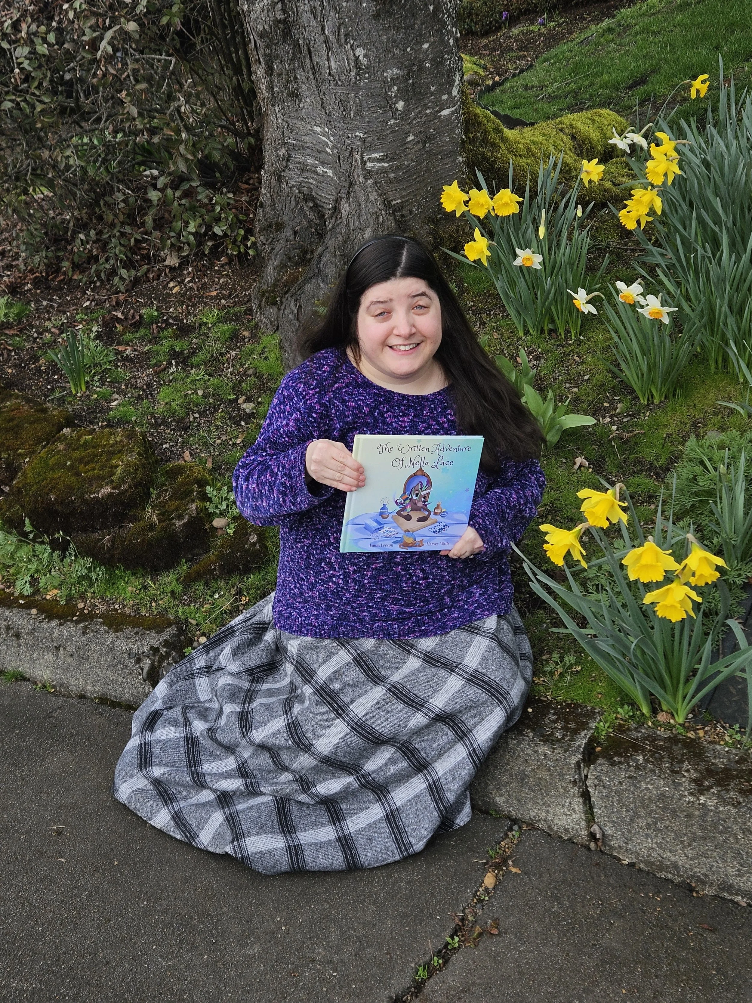 Laura Leeson, children's book author and former educator, holding The Written Adventure of Nella Lace