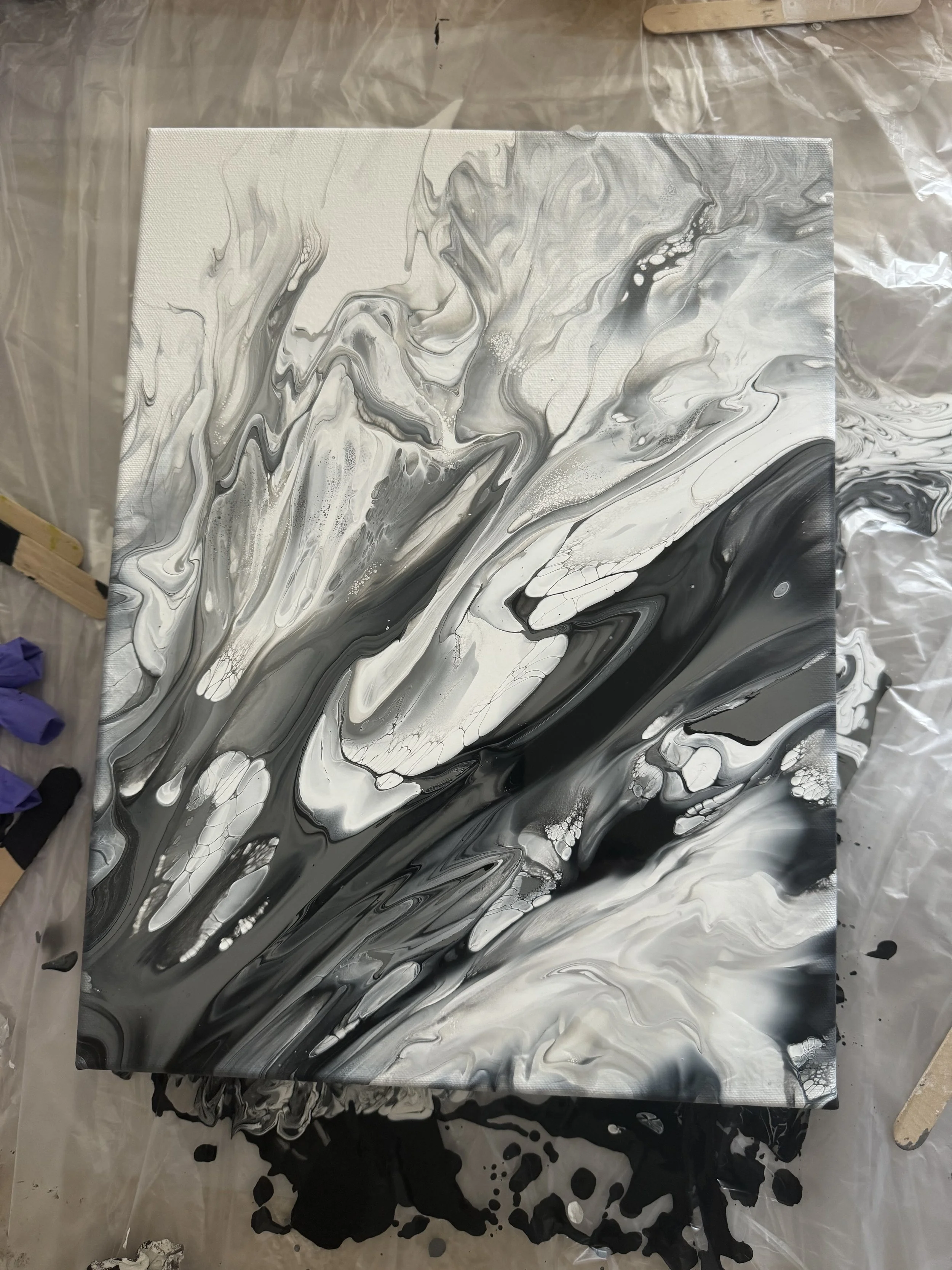 Abstract black, white, and gray marbled paint on canvas.