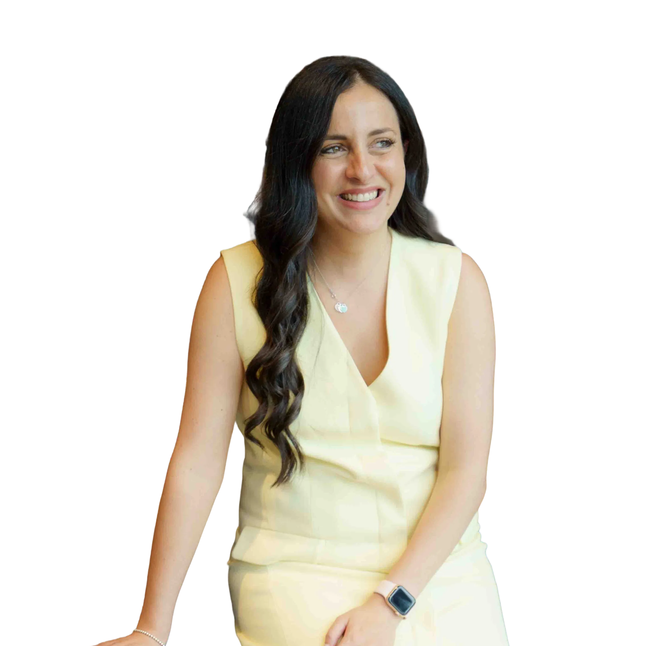 A woman with long dark hair smiling, wearing a sleeveless yellow dress, sitting with her hands resting on her lap, and wearing an Apple Watch.