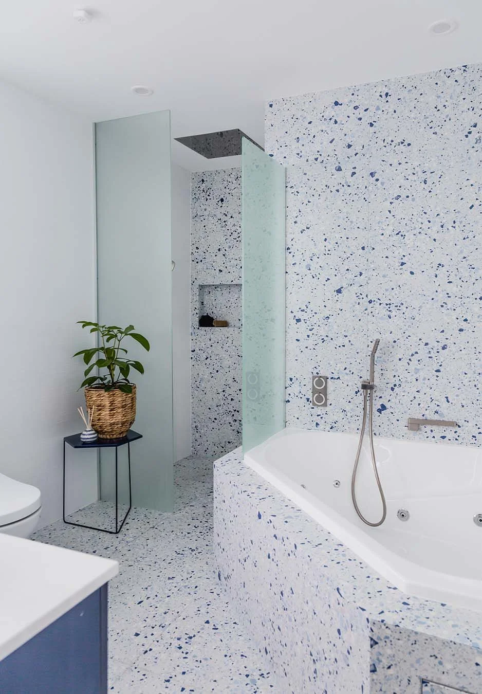 Contemporary bathroom with terrazzo finishes, freestanding bath, glass shower screens and minimal styling for a fresh, modern look
