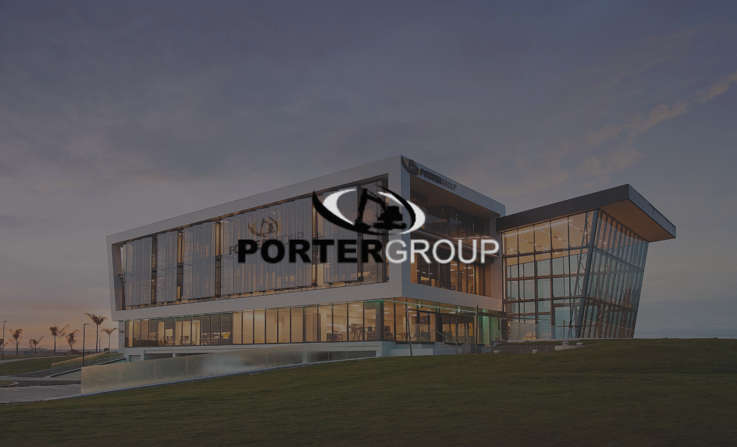 Modern office building with glass facade and the Portergroup logo overlay in the center, situated outdoors during dusk.
