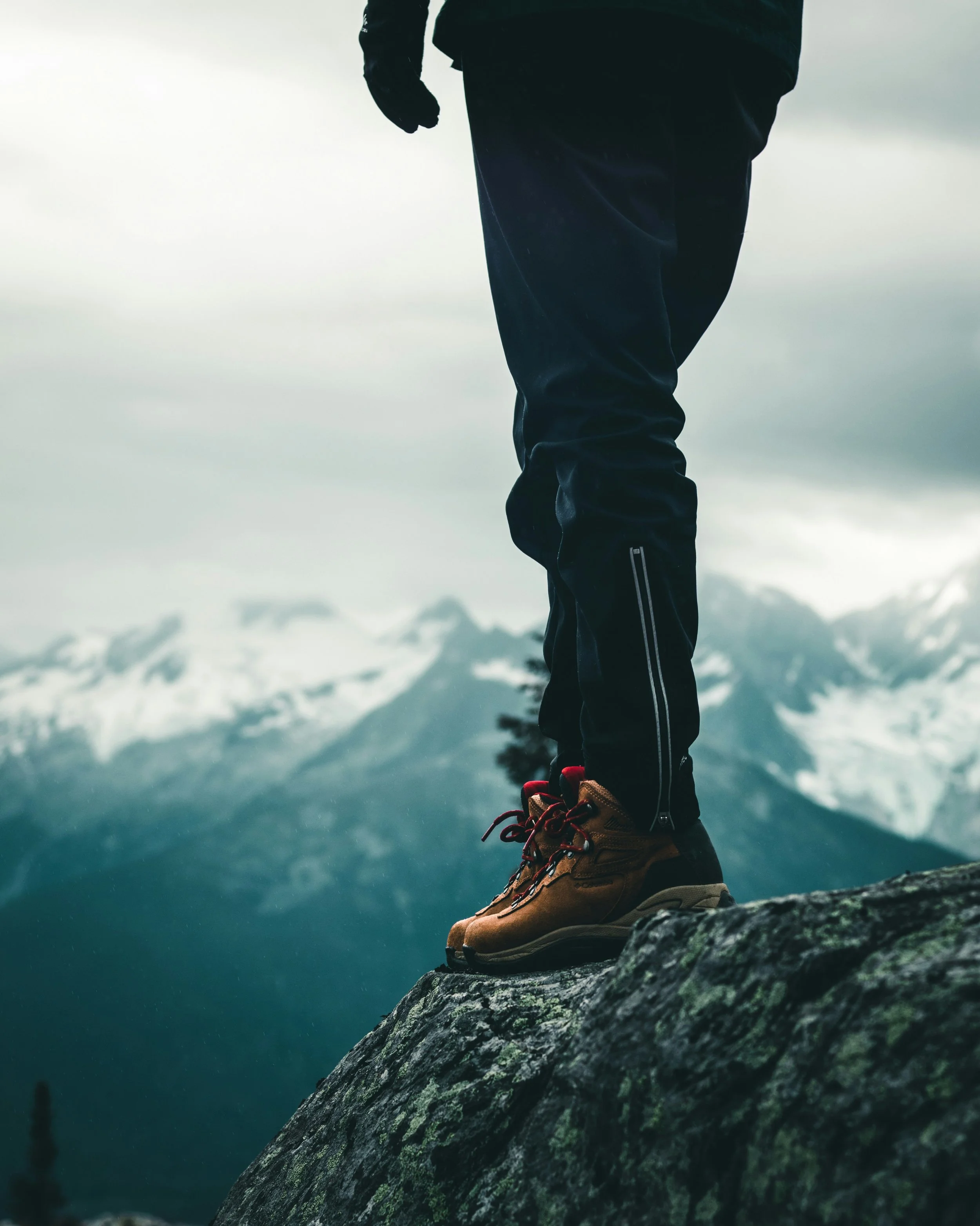 Man standing at a mountain summit representing peak performance and vitality for men over 40