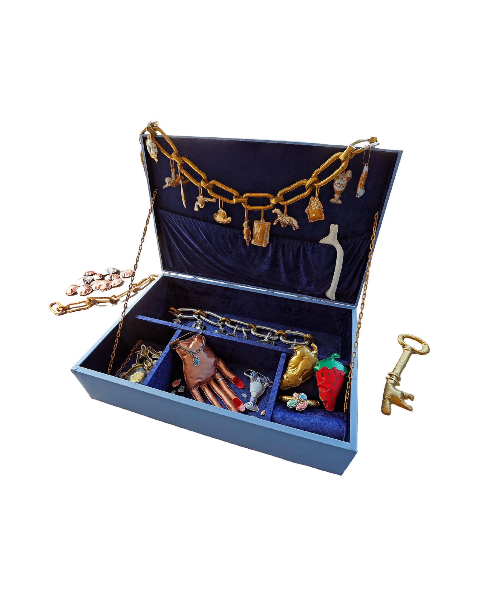 Open giant jewelry box with blue velvet interior displaying gold, silver, and colorful jewelry, accessories, and charms, with a necklace hanging inside.