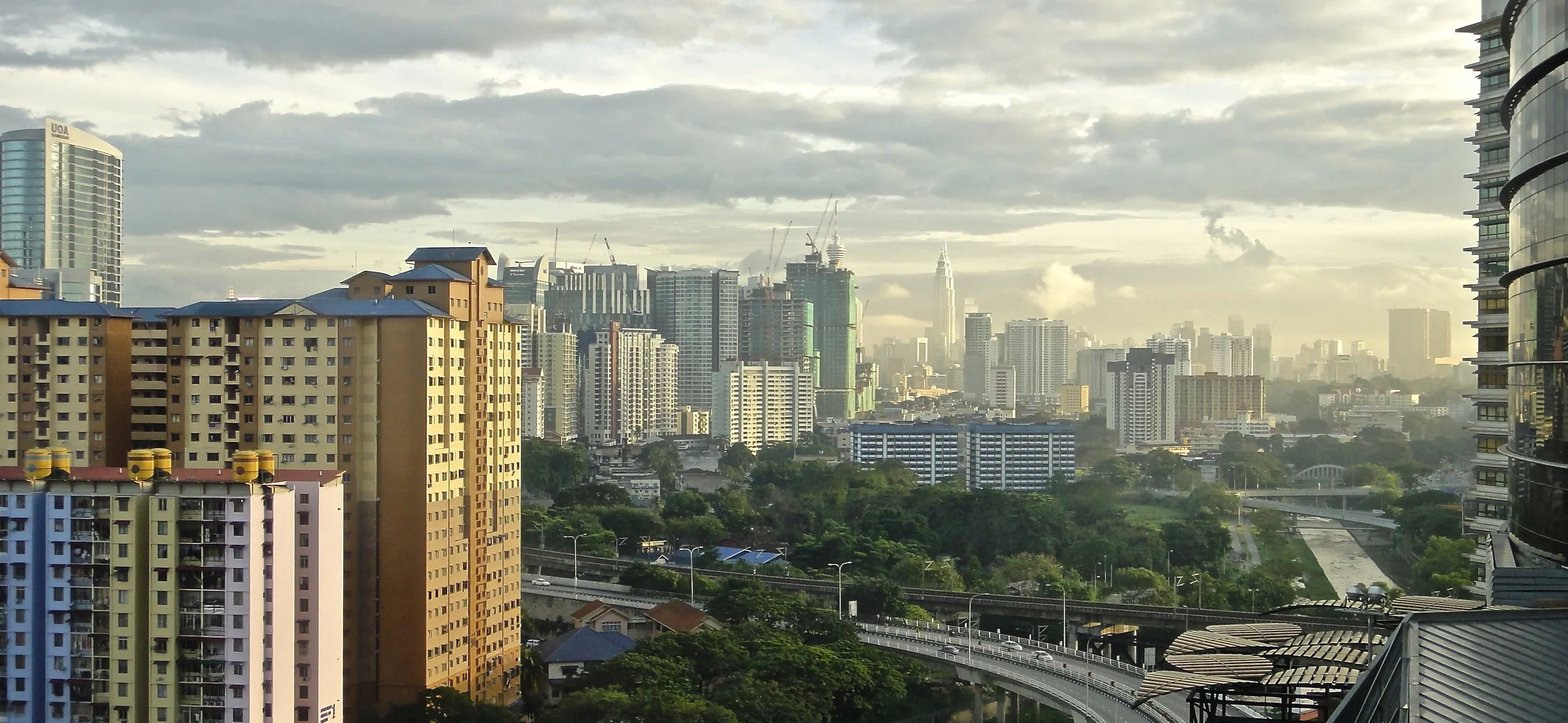 Allow me to end this story with a scene of the urban city. The horizon blanketed with smog and peppered with random spikes of concrete towers. Glow of dawn cast an unusual tint of glamour over the distant twin towers - associated with being a city of