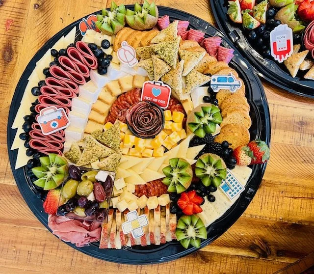 Assorted cheese, meats, fruits, and vegetables on a large round platter, arranged for a party or gathering.