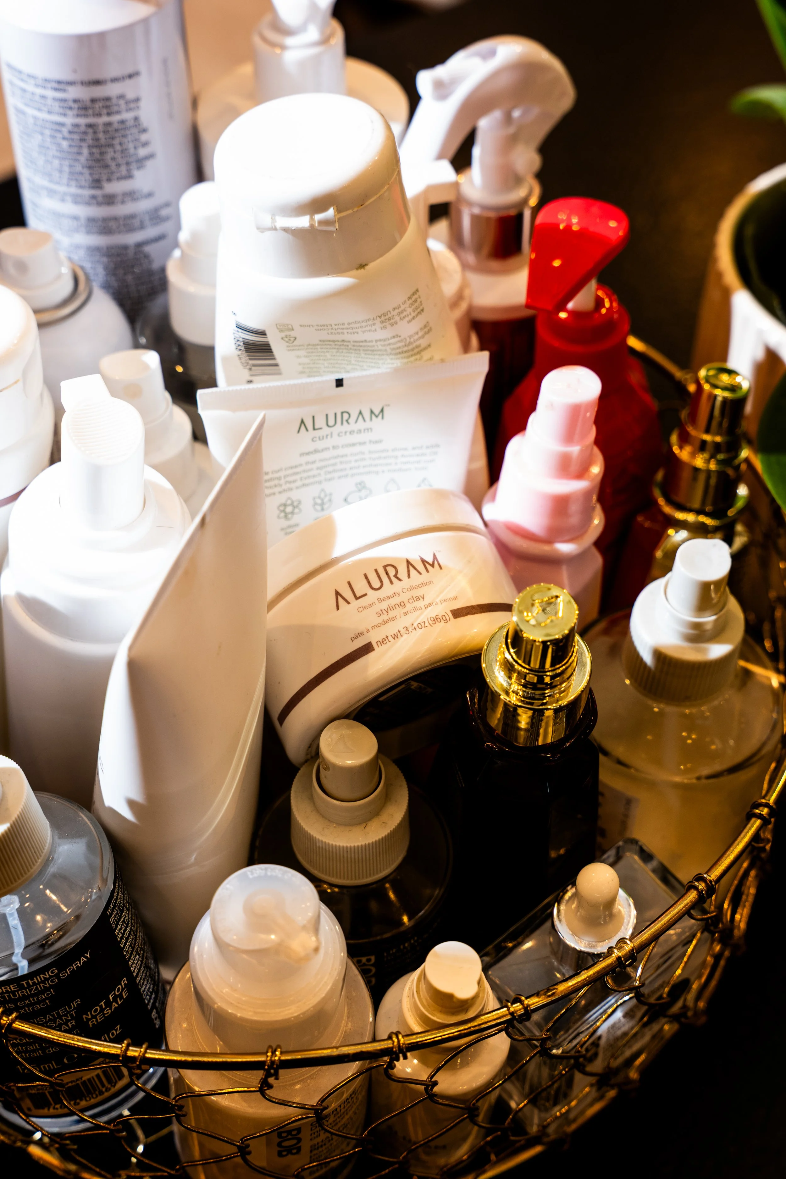 Various skincare and cosmetic bottles and jars in a wire basket.