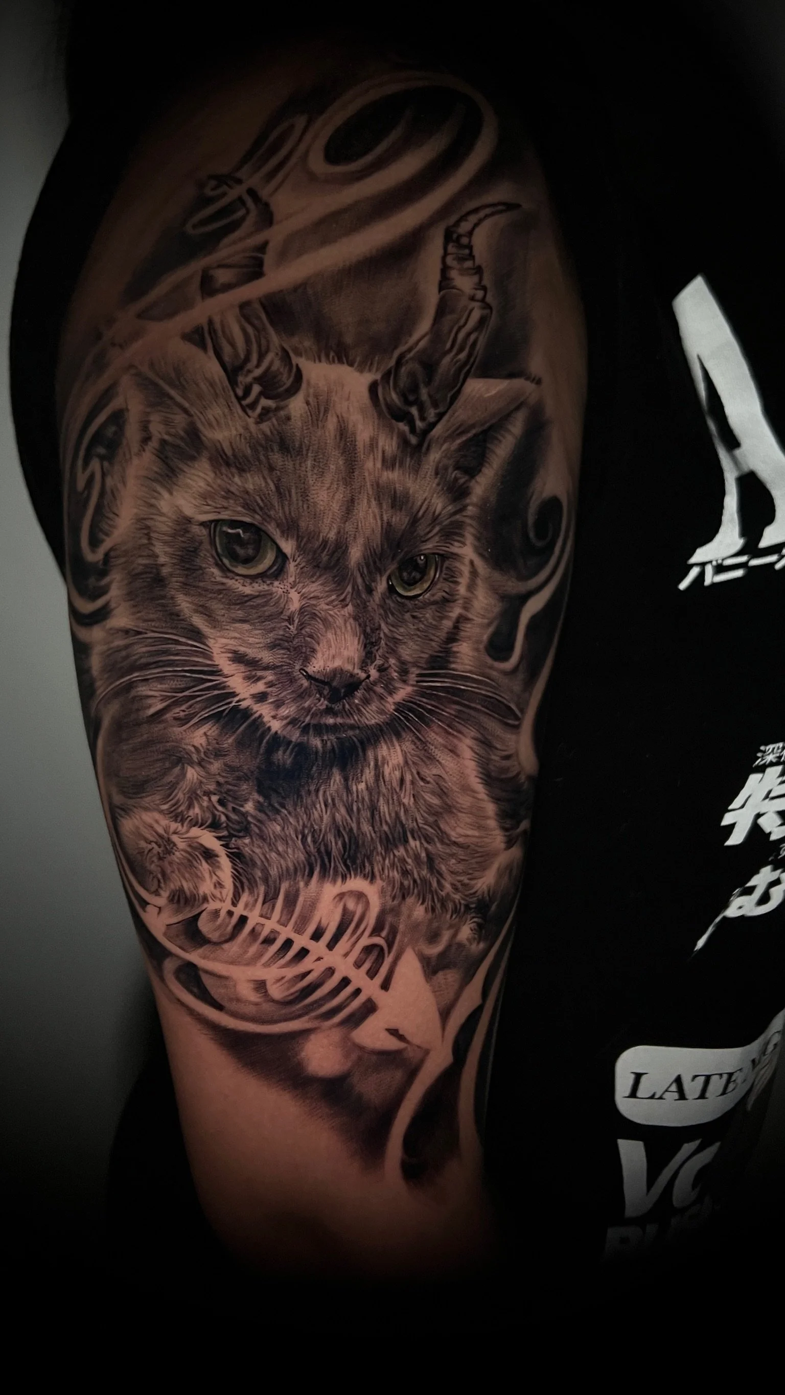 Black and gray realism tattoo of a wildcat with detailed fur and piercing eyes on a person's upper arm, with a DNA helix and abstract designs around it.