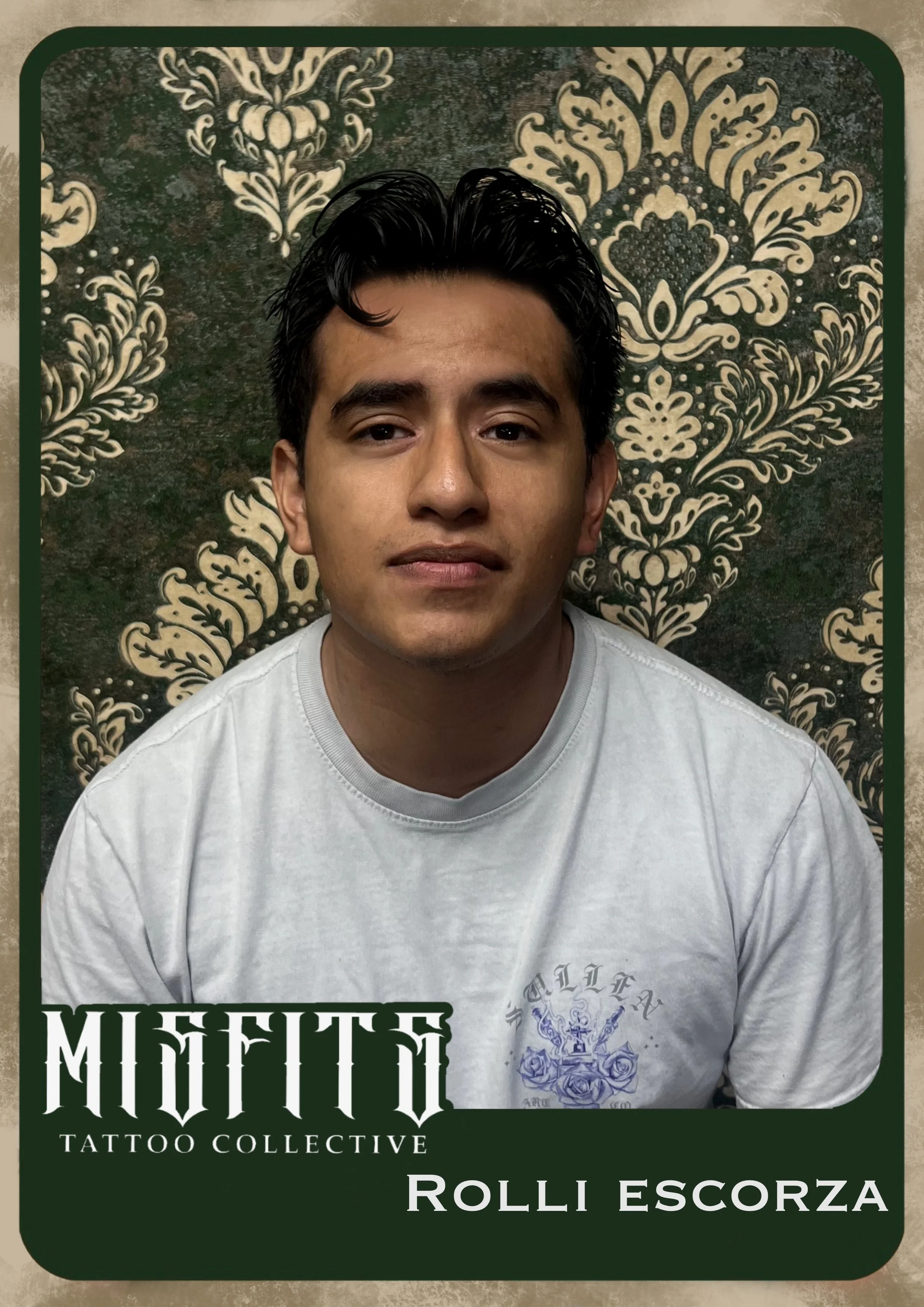 A young man with dark hair and a slight smile, wearing a white t-shirt, posing in front of a decorative dark green and gold patterned background.