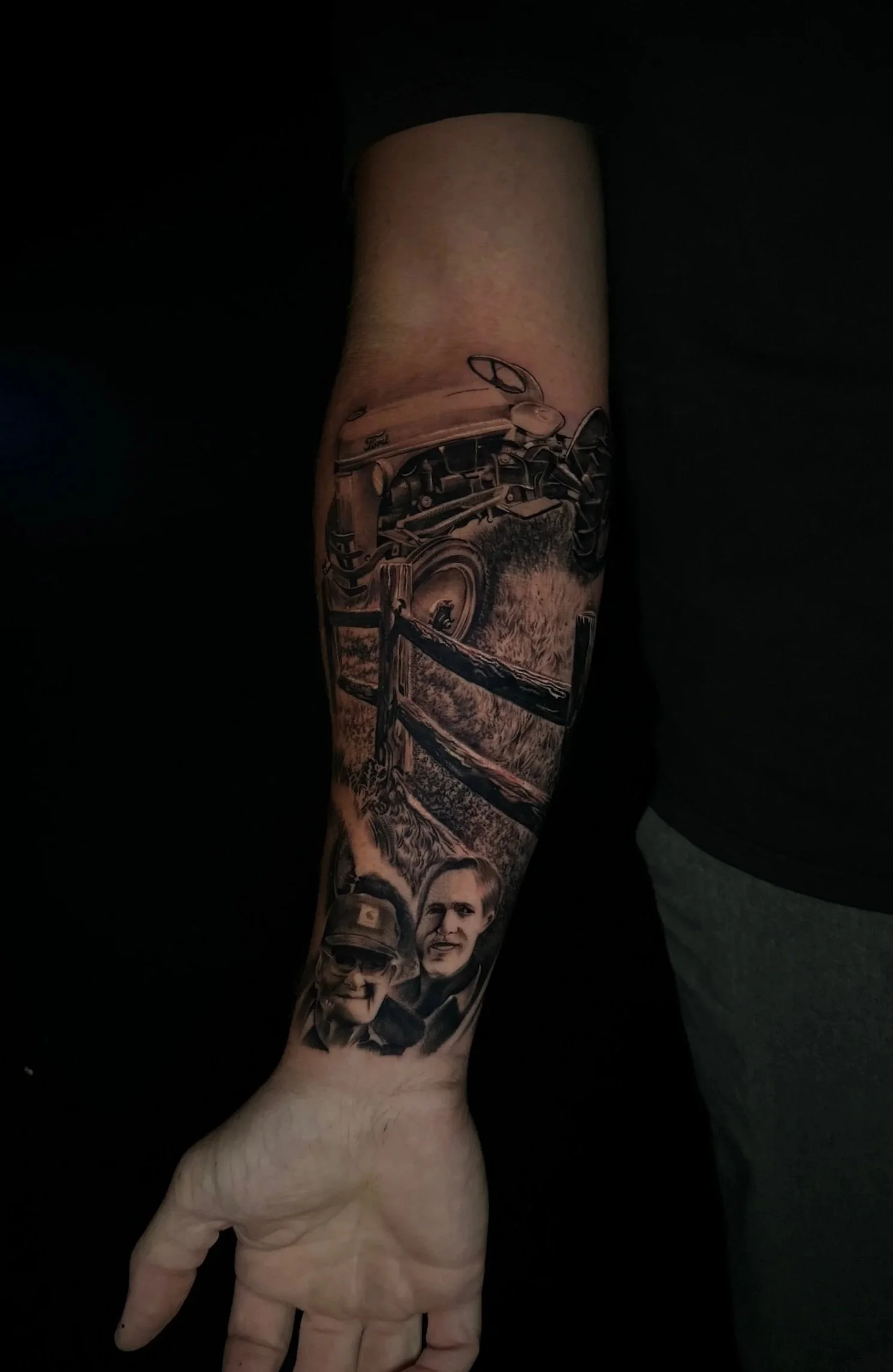 Tattoo sleeve featuring a vintage car, a wooden fence, two men's portraits, and scenic landscape.