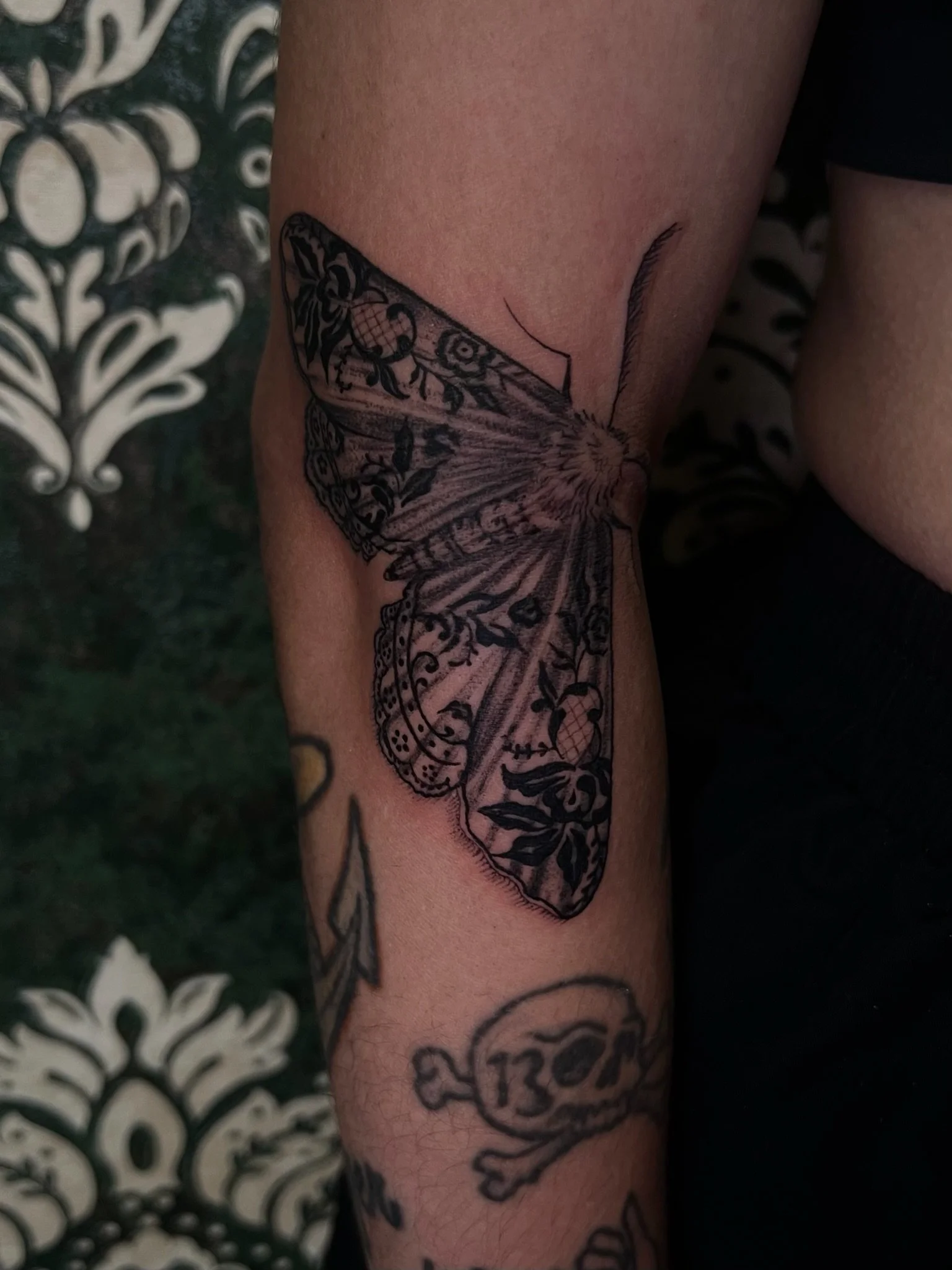 A tattoo of a butterfly with detailed wings and floral patterns on the person's arm.