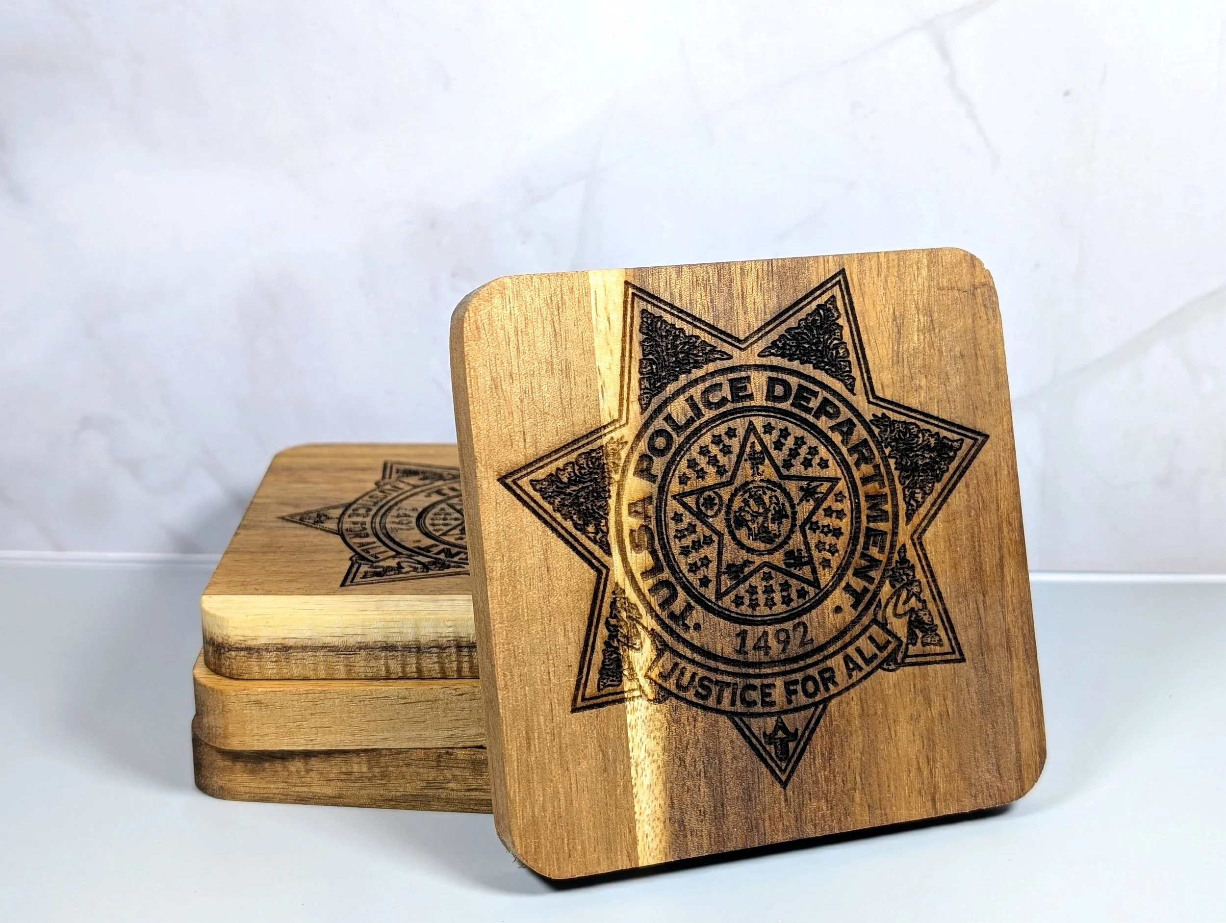 A wooden box with a black police badge logo printed on the top. The badge reads "POLICE DEPARTMENT" with the phrase "JUSTICE FOR ALL" at the bottom.