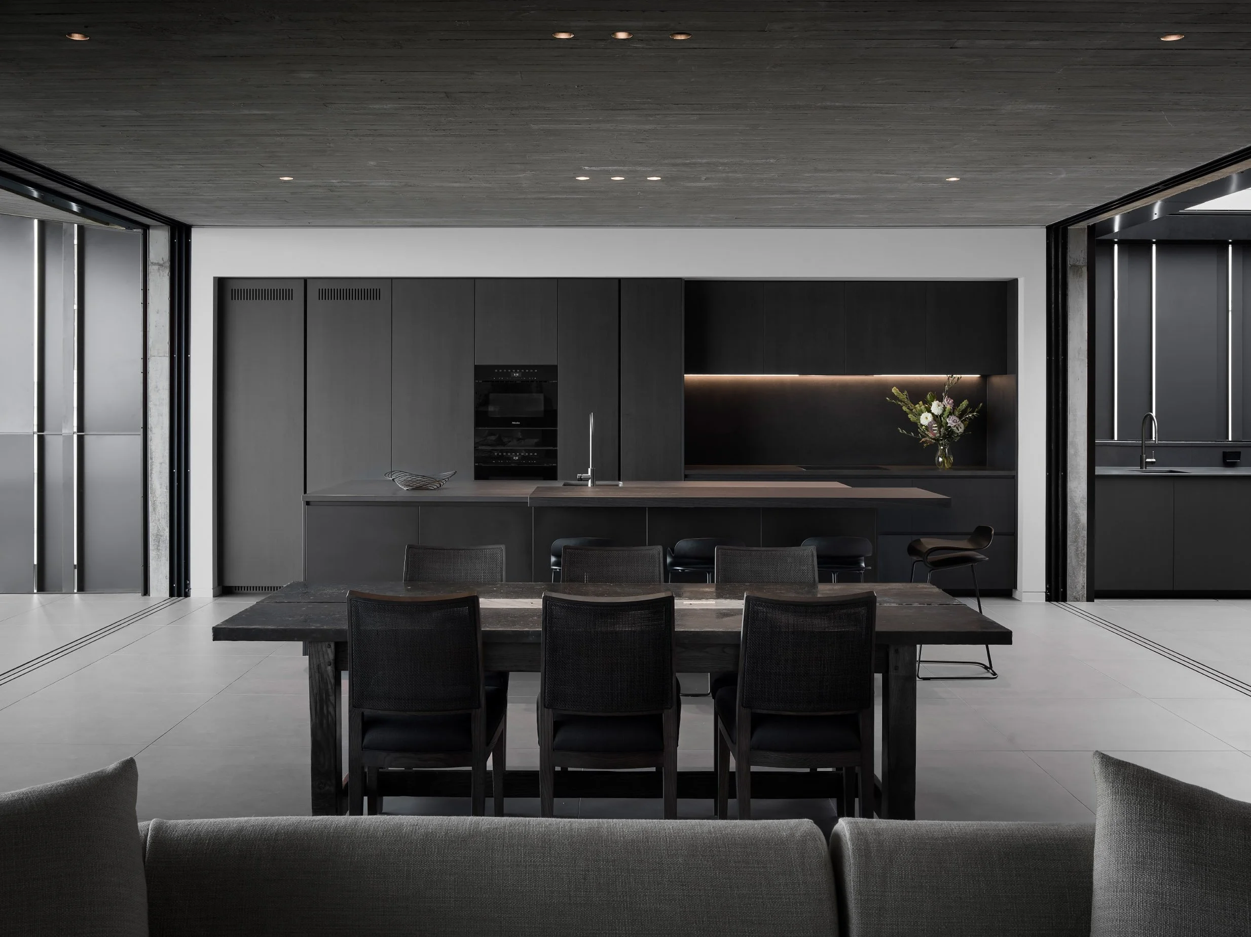 Modern dark kitchen with island and dining space custom build