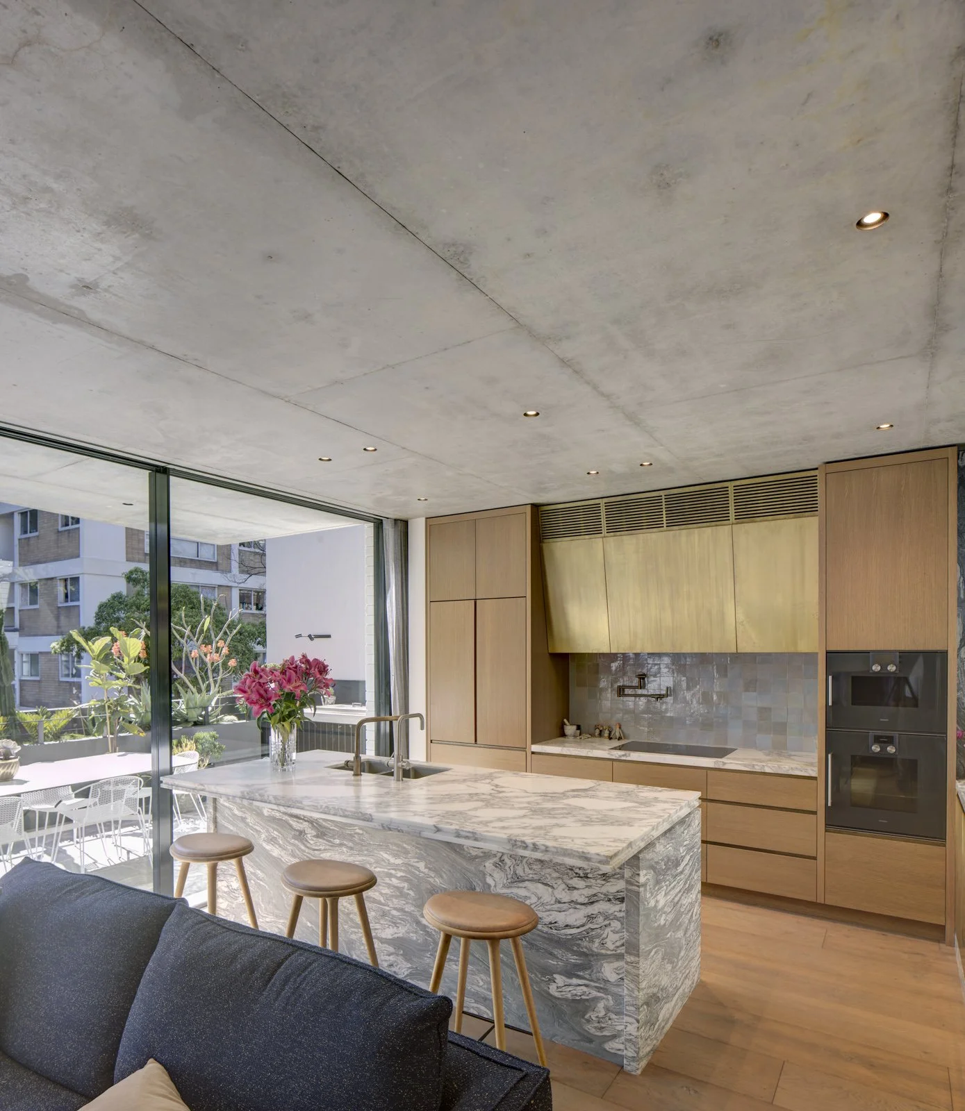 aged brass kitchen with marble bench tops concrete ceiling, can lights from Tovo lighting oak veneer joinery