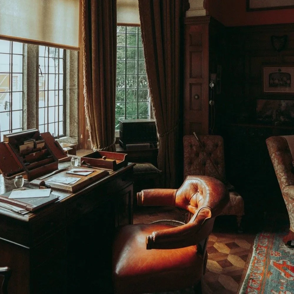A leather armchair behind a desk in the historic study at Lanhydrock House in Cornwall.