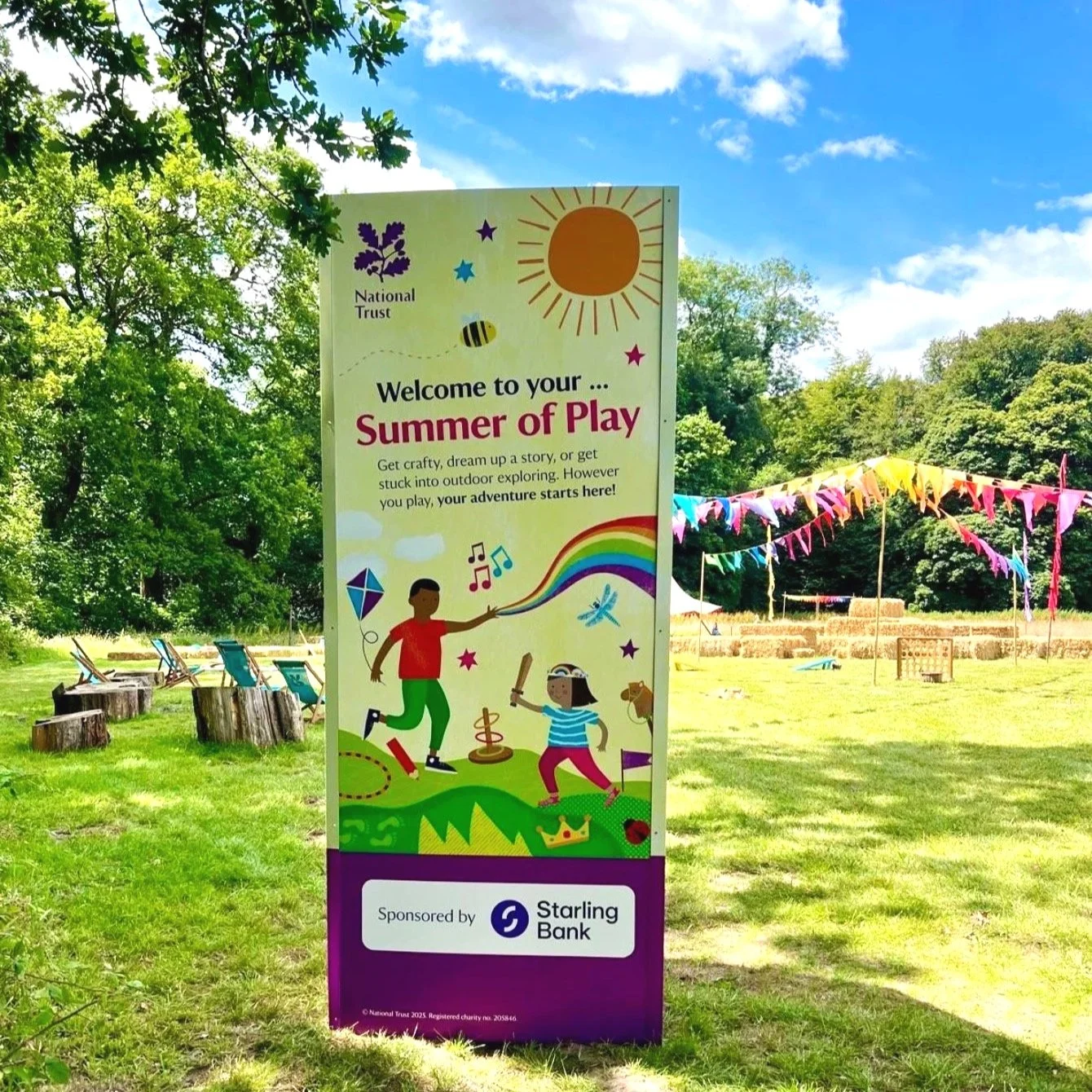 A large panel advertising 'Summer of Play' in a field with play equipment, deckchairs, and bunting.